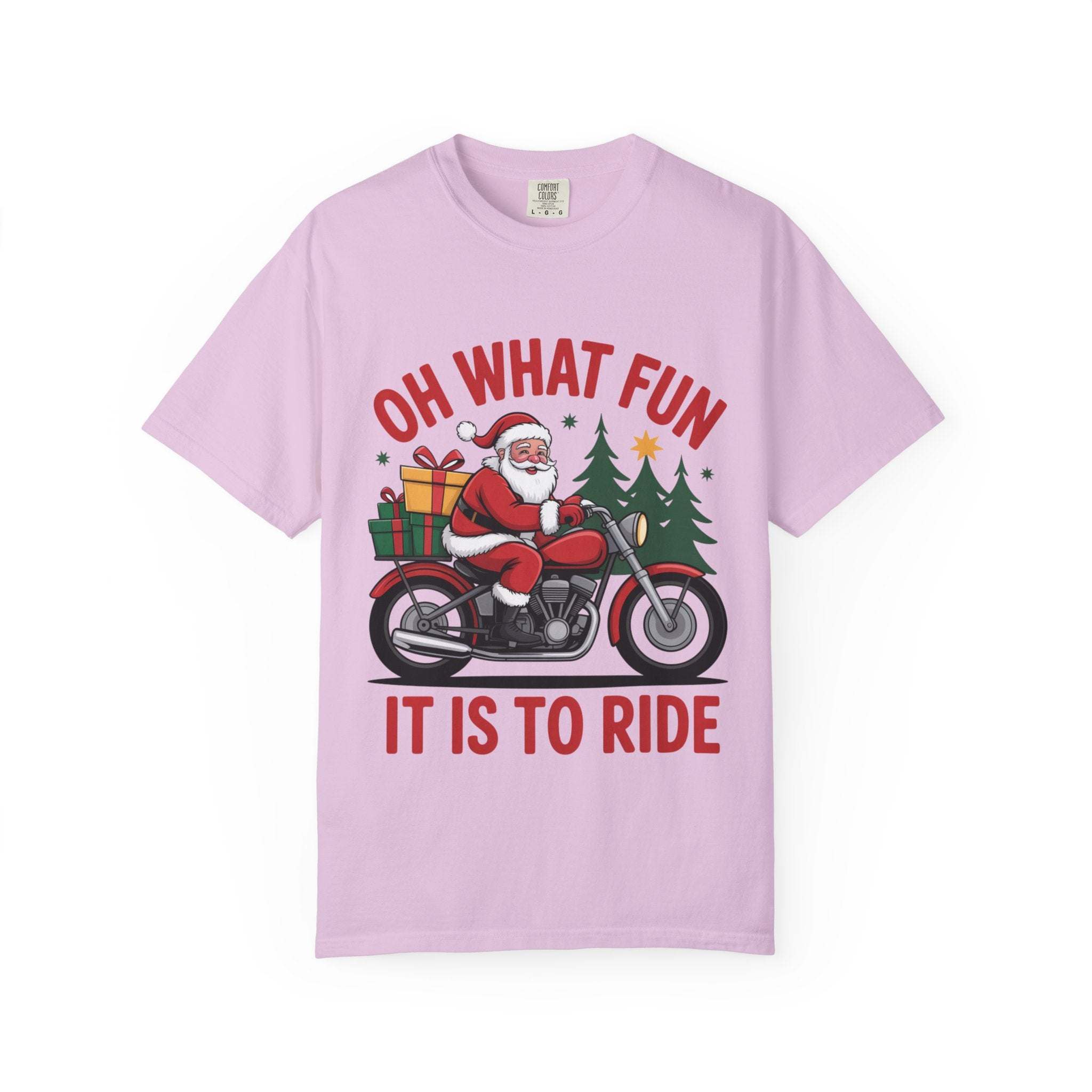 Pink t-shirt featuring Santa on a motorcycle with Christmas gifts and trees, festive holiday design.