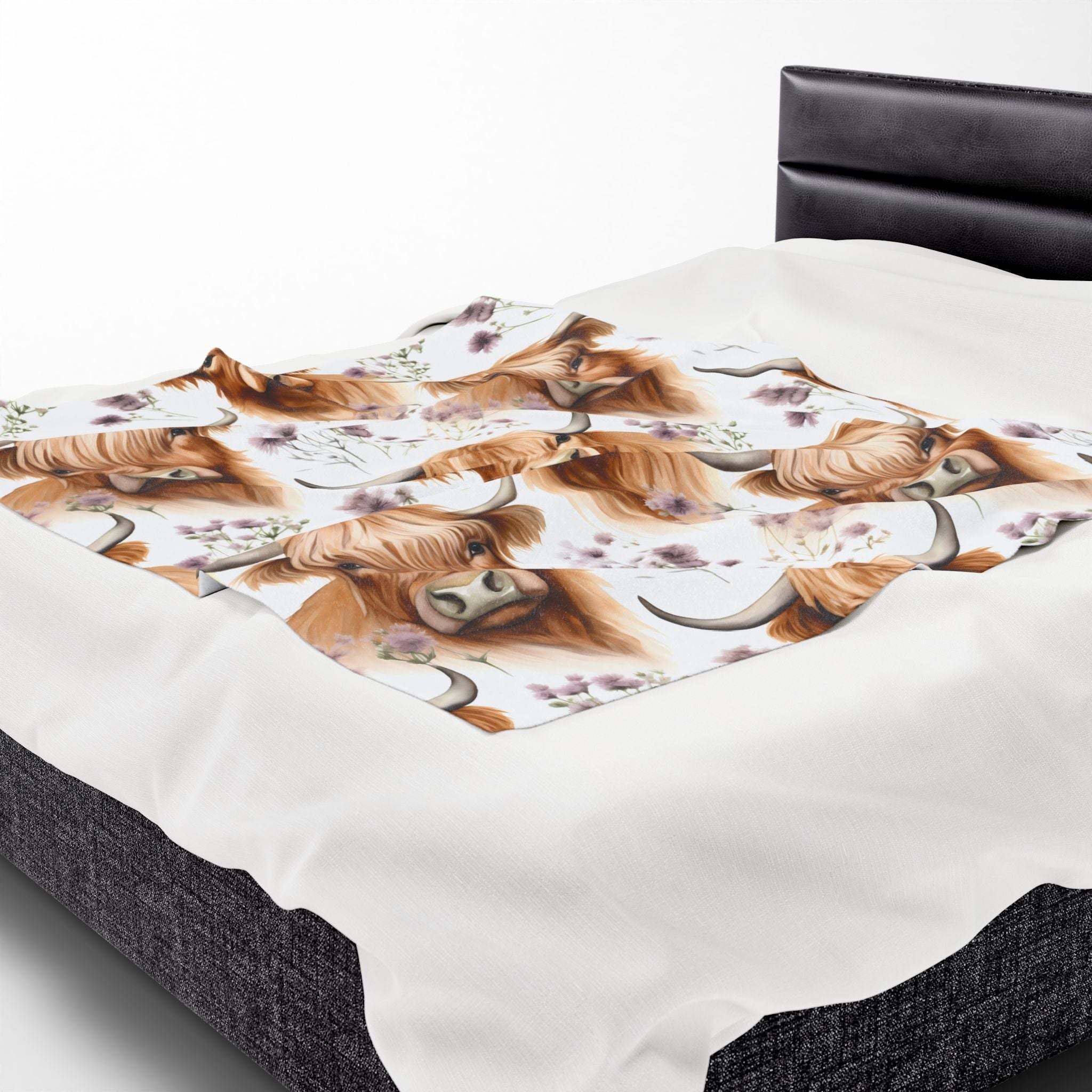 Velveteen plush blanket with floral Highland cow design on bed