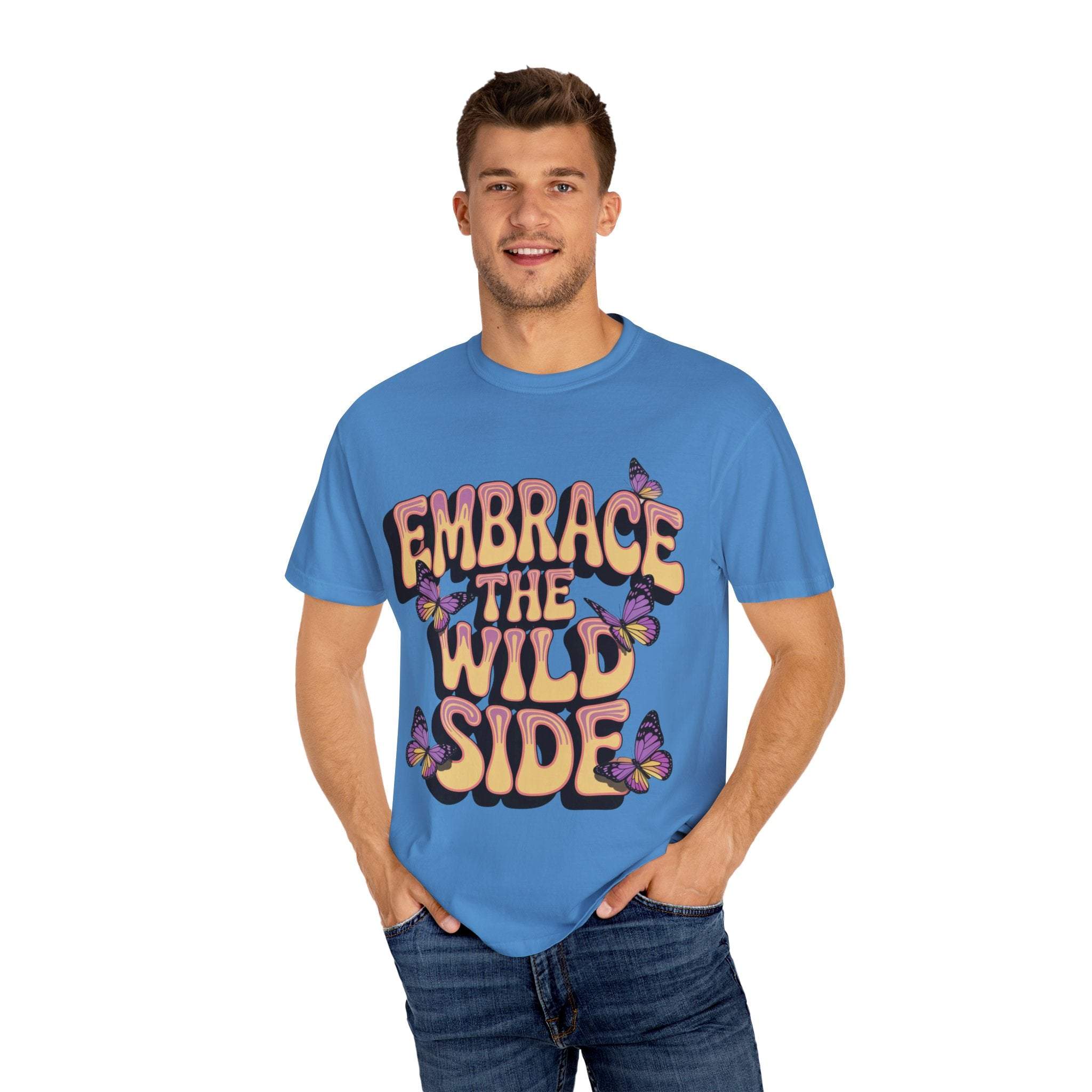 Blue garment-dyed T-shirt with "Embrace the Wild Side" print featuring butterflies worn by smiling man