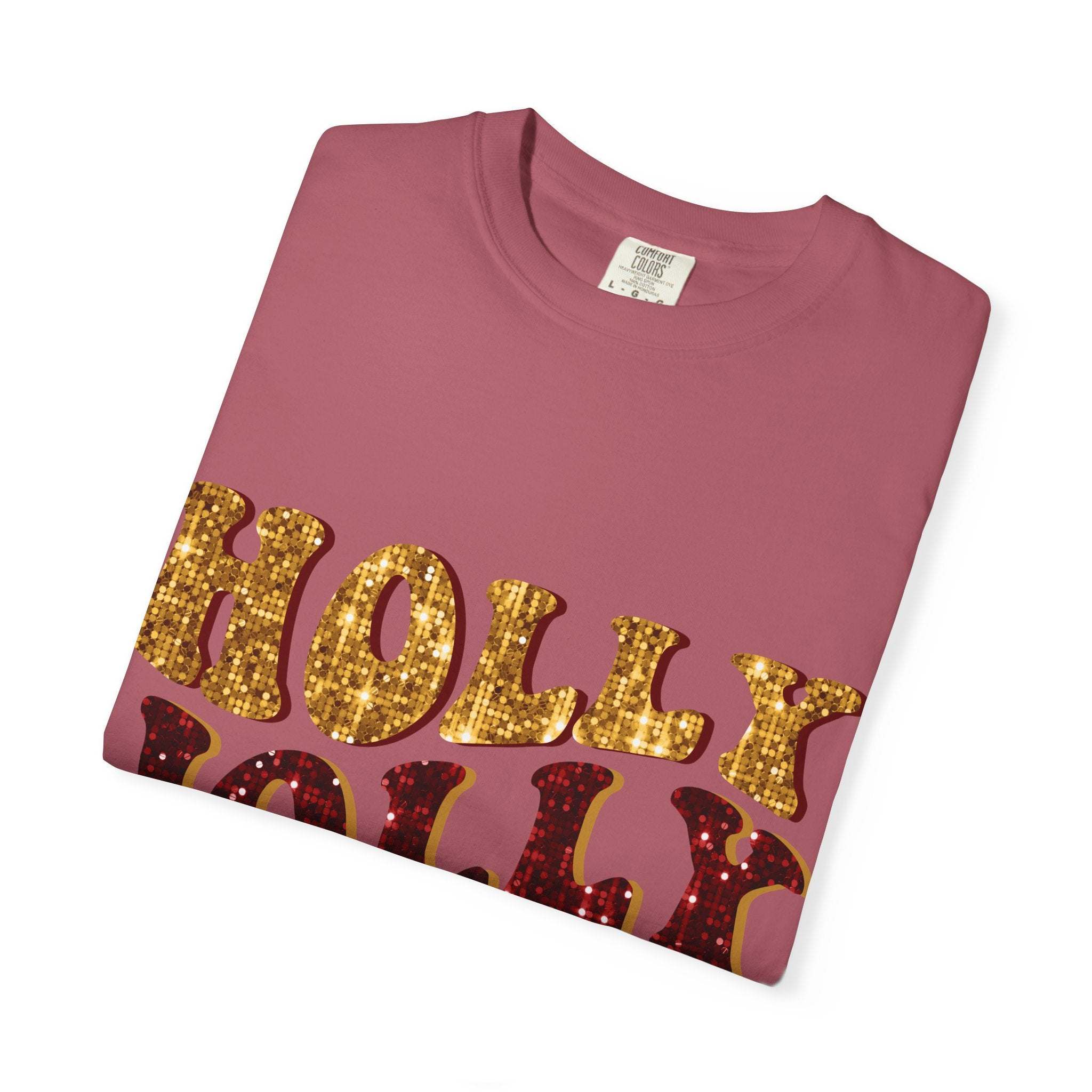 Folded maroon Faux Glitter Holly Jolly Mama t-shirt with gold and red glitter text on front