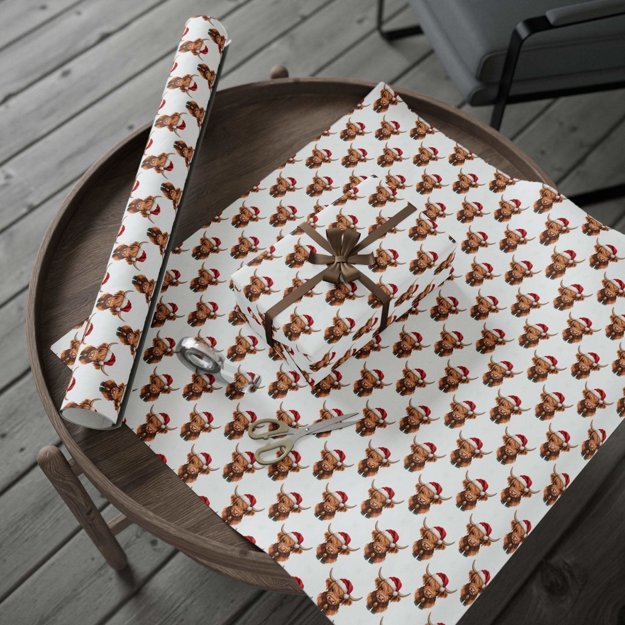 Gift Wrapping Papers with Santa Highland Cows design on thick matte paper roll and wrapped gift box on wooden table