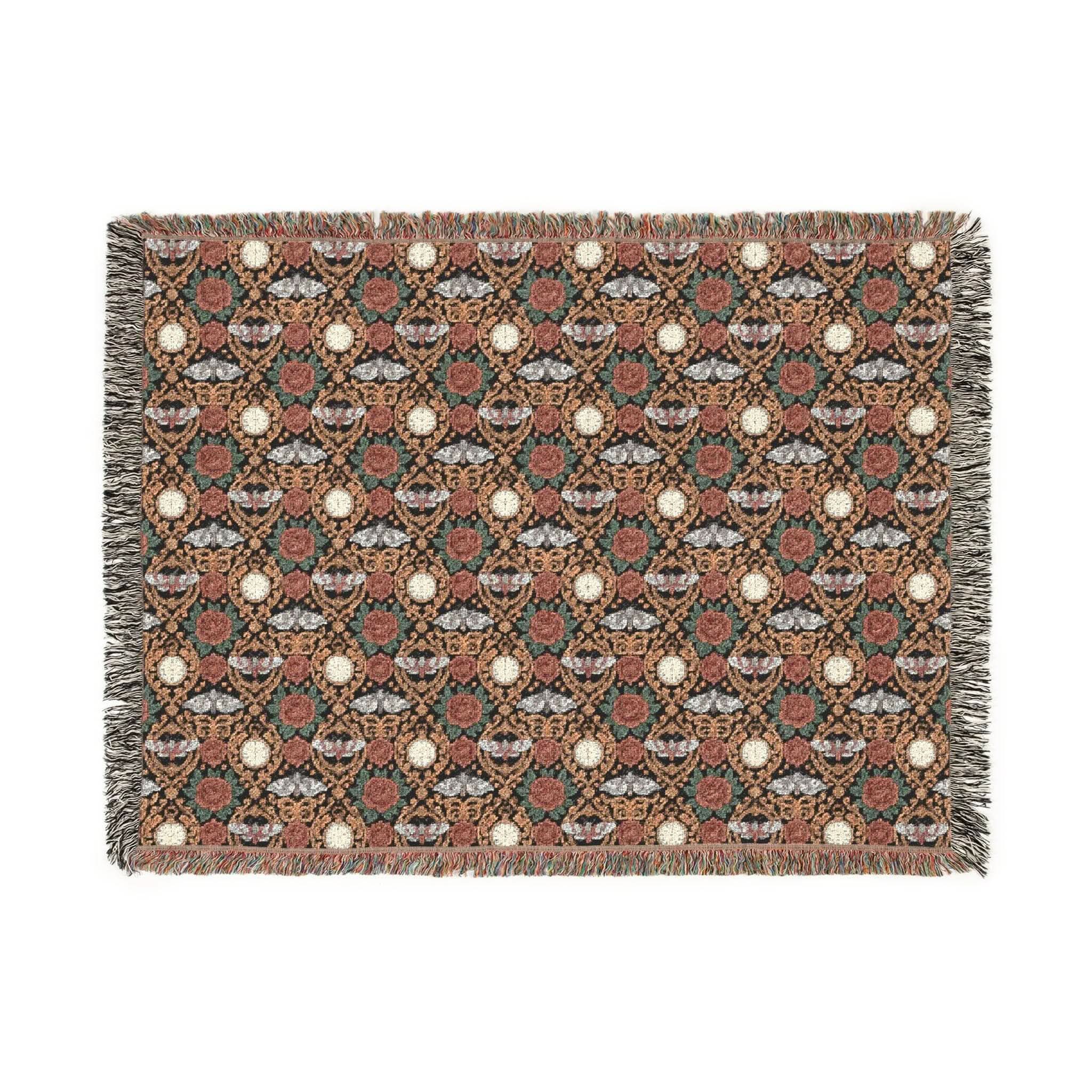 Victorian Gothmas Woven Blanket with candlelight colors and colorful fringed edges draped on a dark velvet bed