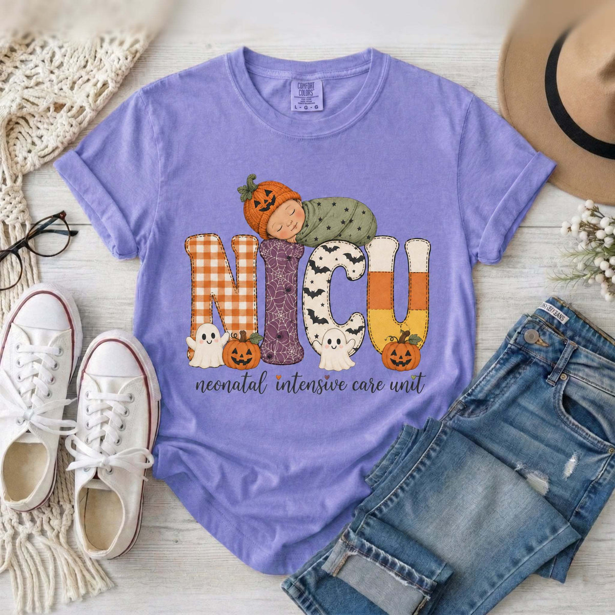 Violet NICU nurse Halloween T-shirt with patchwork lettering, a sleeping baby in a pumpkin hat, ghosts, and jack-o’-lanterns.