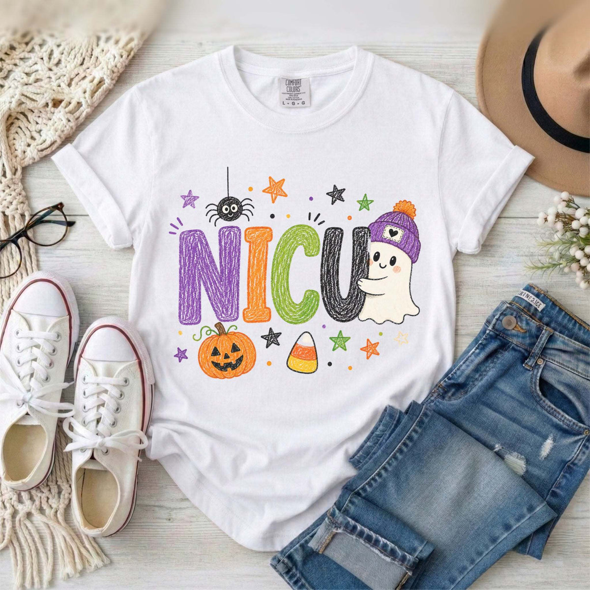 White NICU nurse Halloween T-shirt with colorful crayon-style lettering, a smiling ghost in a purple beanie, pumpkin, and candy corn.