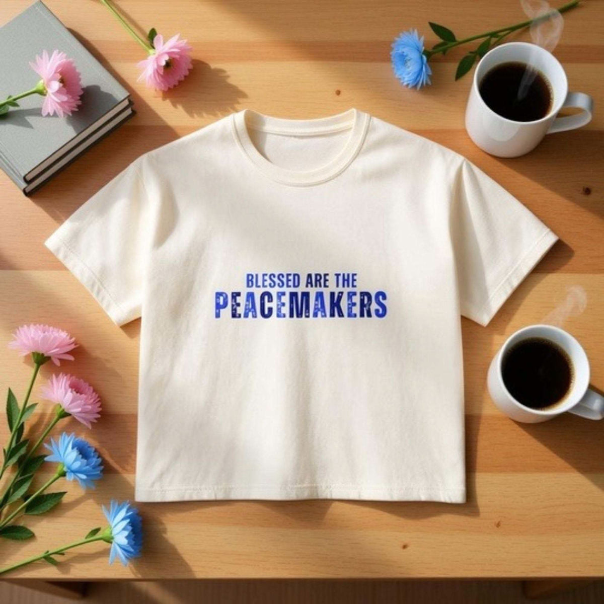 Women's boxy tee with "Blessed be the Peacemakers" text in blue on white cotton shirt
