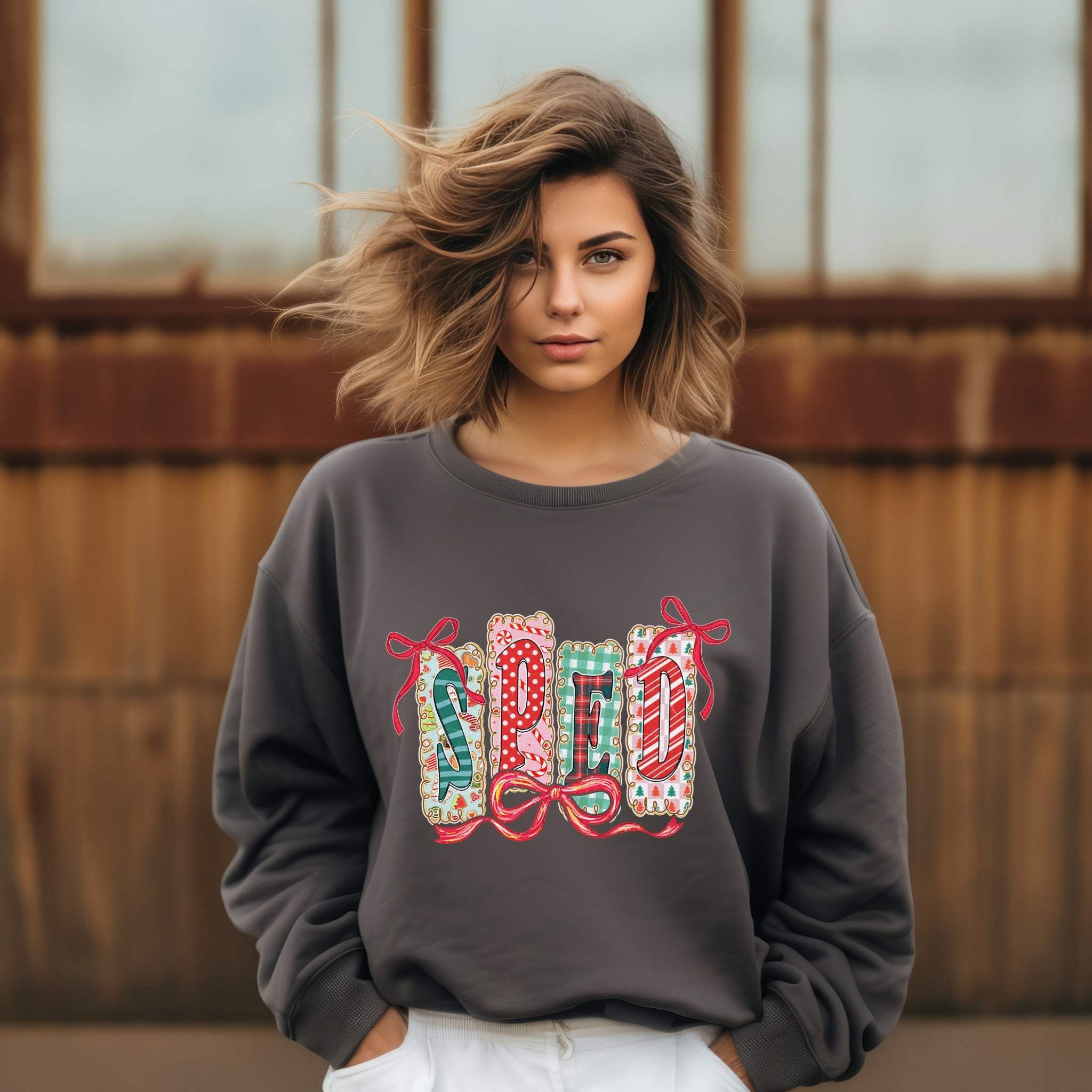 Woman wearing gray garment-dyed sweatshirt with festive SPED Christmas design