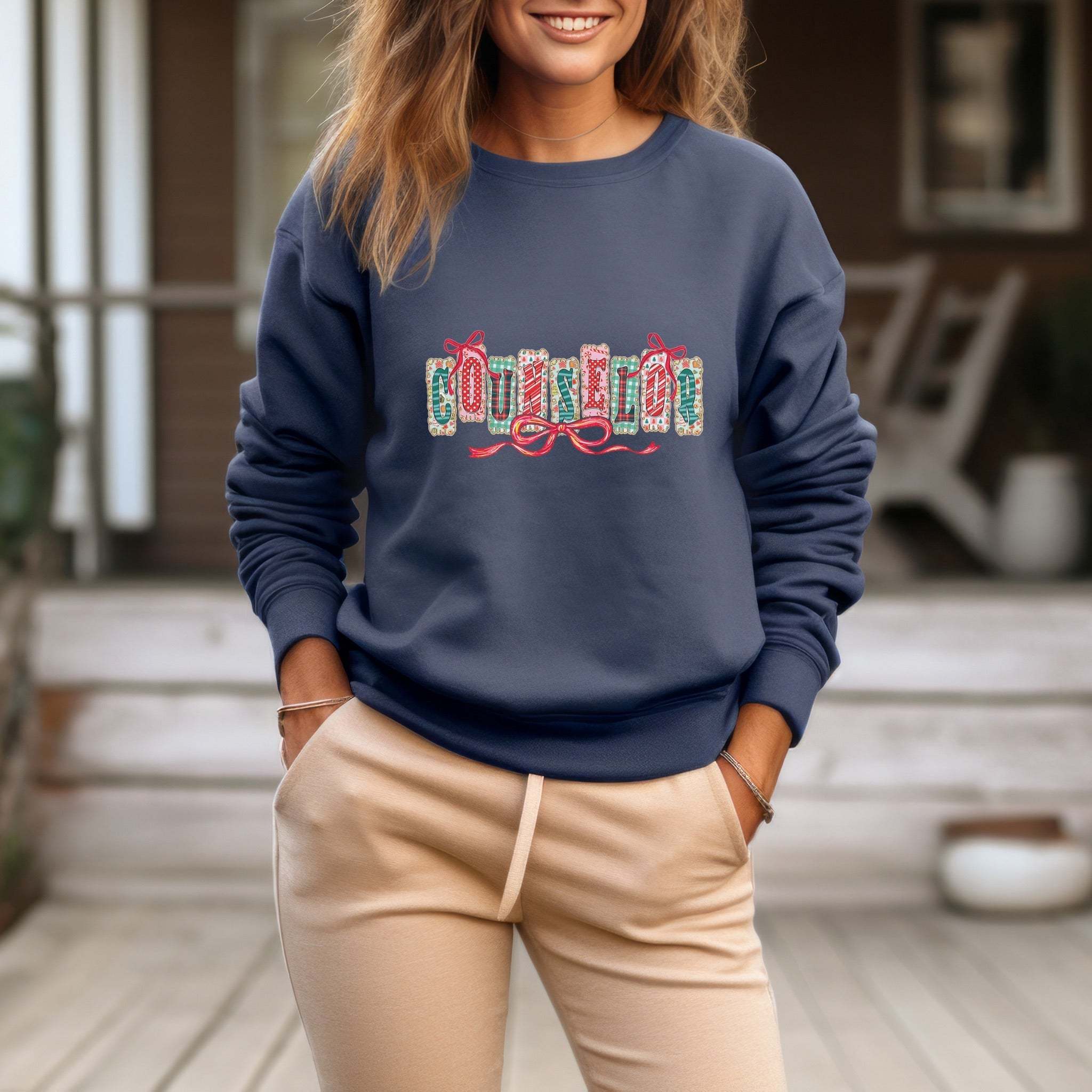 woman wearing blue garment-dyed sweatshirt with festive Christmas embroidery and beige pants outdoors