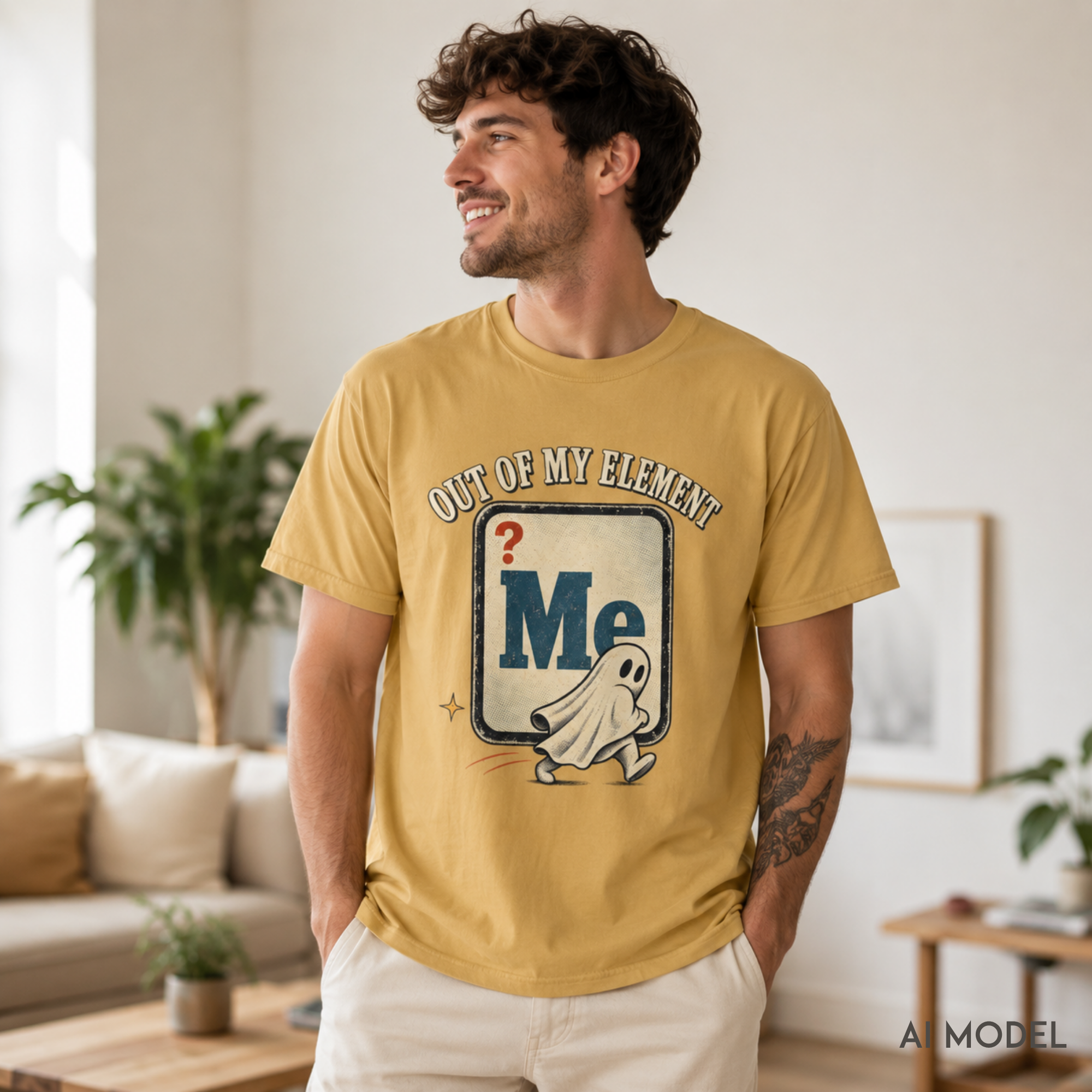 Male model wearing a mustard yellow “Out of My Element” ghost graphic T-shirt with a retro distressed print in a warm modern living room.