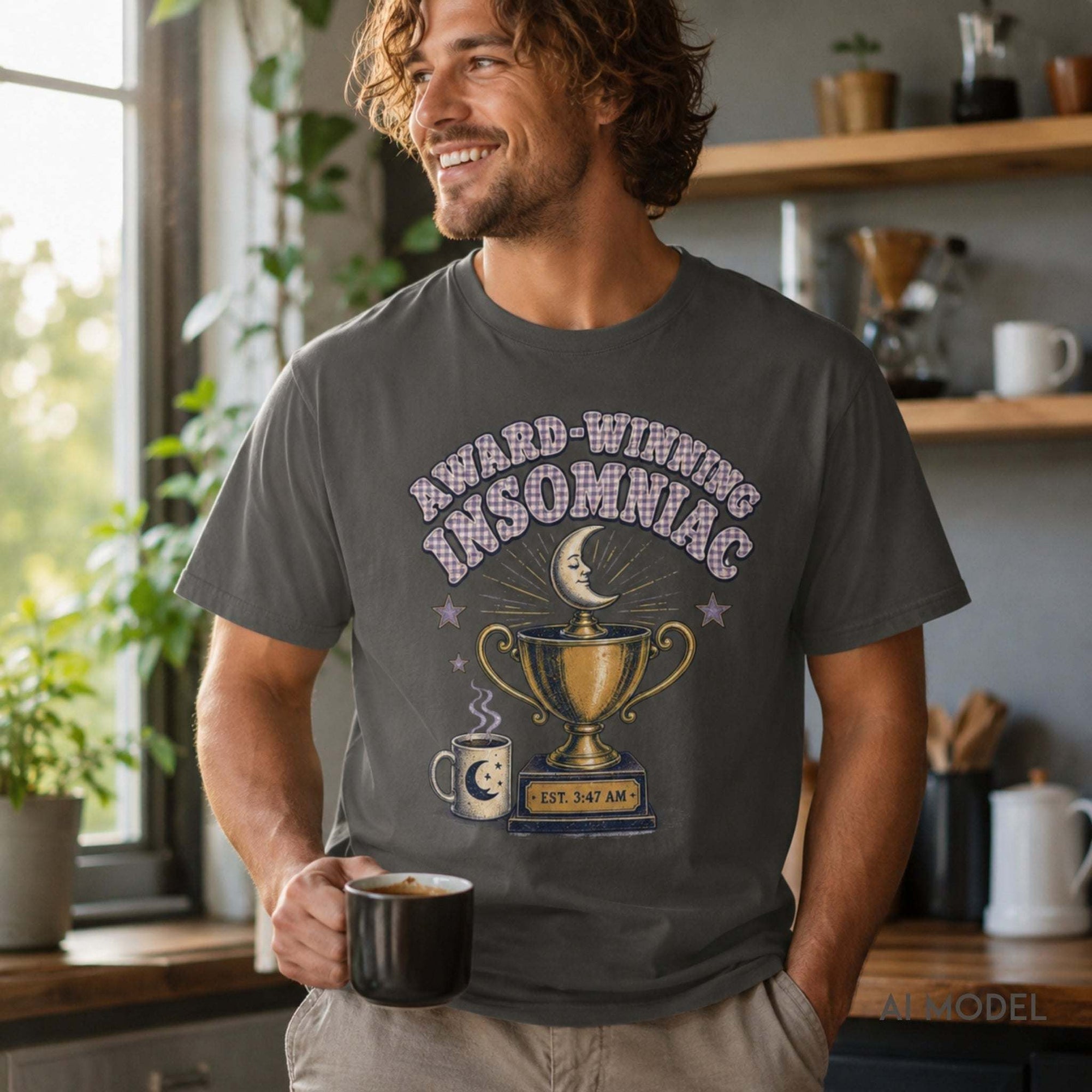 Male model wearing a pepper gray Award-Winning Insomniac graphic T-shirt with vintage moon, coffee mug and trophy design while holding coffee.
