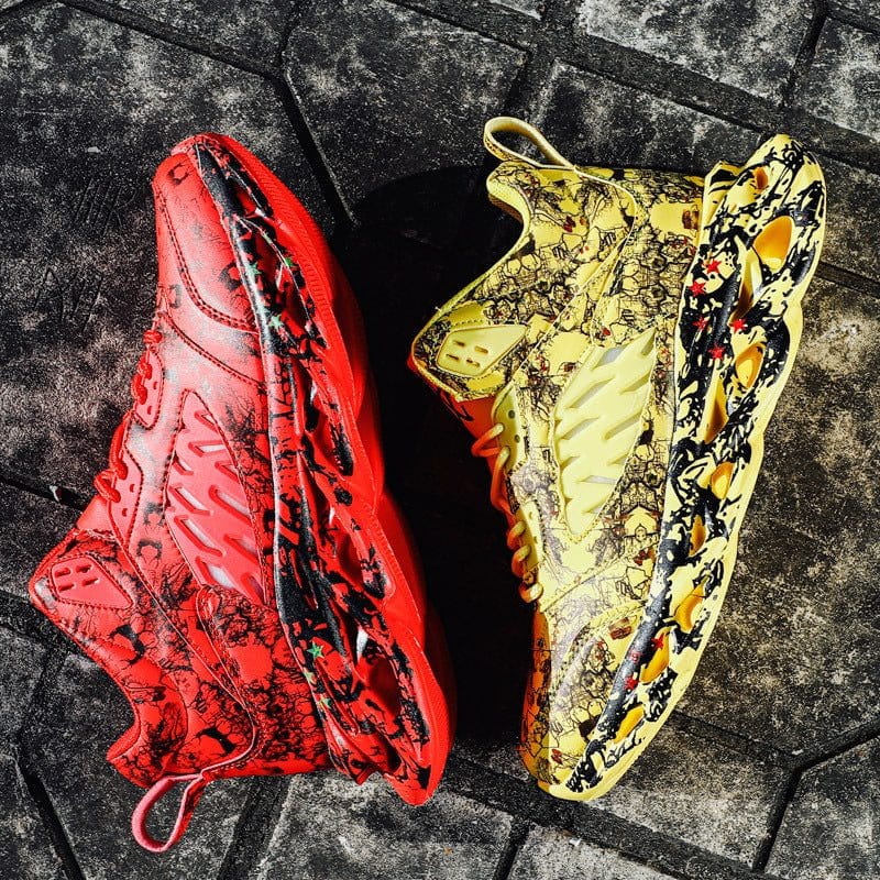 pair of trendy camouflage sports blade old shoes in red and yellow with patterned soles on stone pavement
