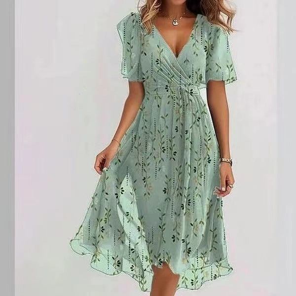 Woman wearing a mint green chiffon printed short sleeve dress with V-neck and mid-length skirt
