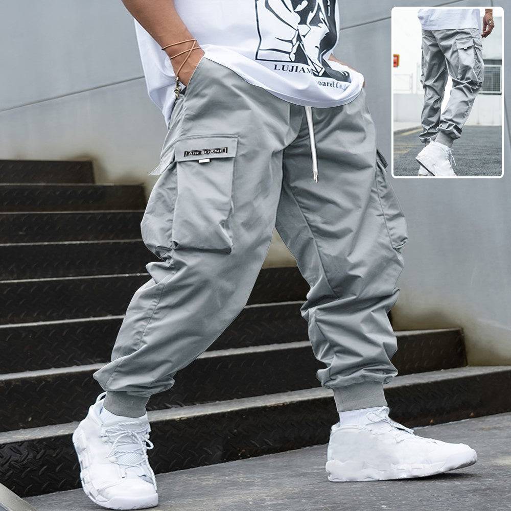 Men's grey multi-pocket cargo pants with drawstring waist and elastic cuffs, casual hip-hop streetwear style