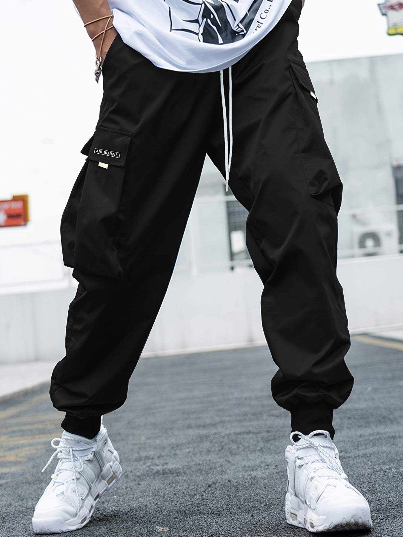 Black multi-pocket cargo pants for men with drawstring waist, casual hip-hop style, and outdoor streetwear design