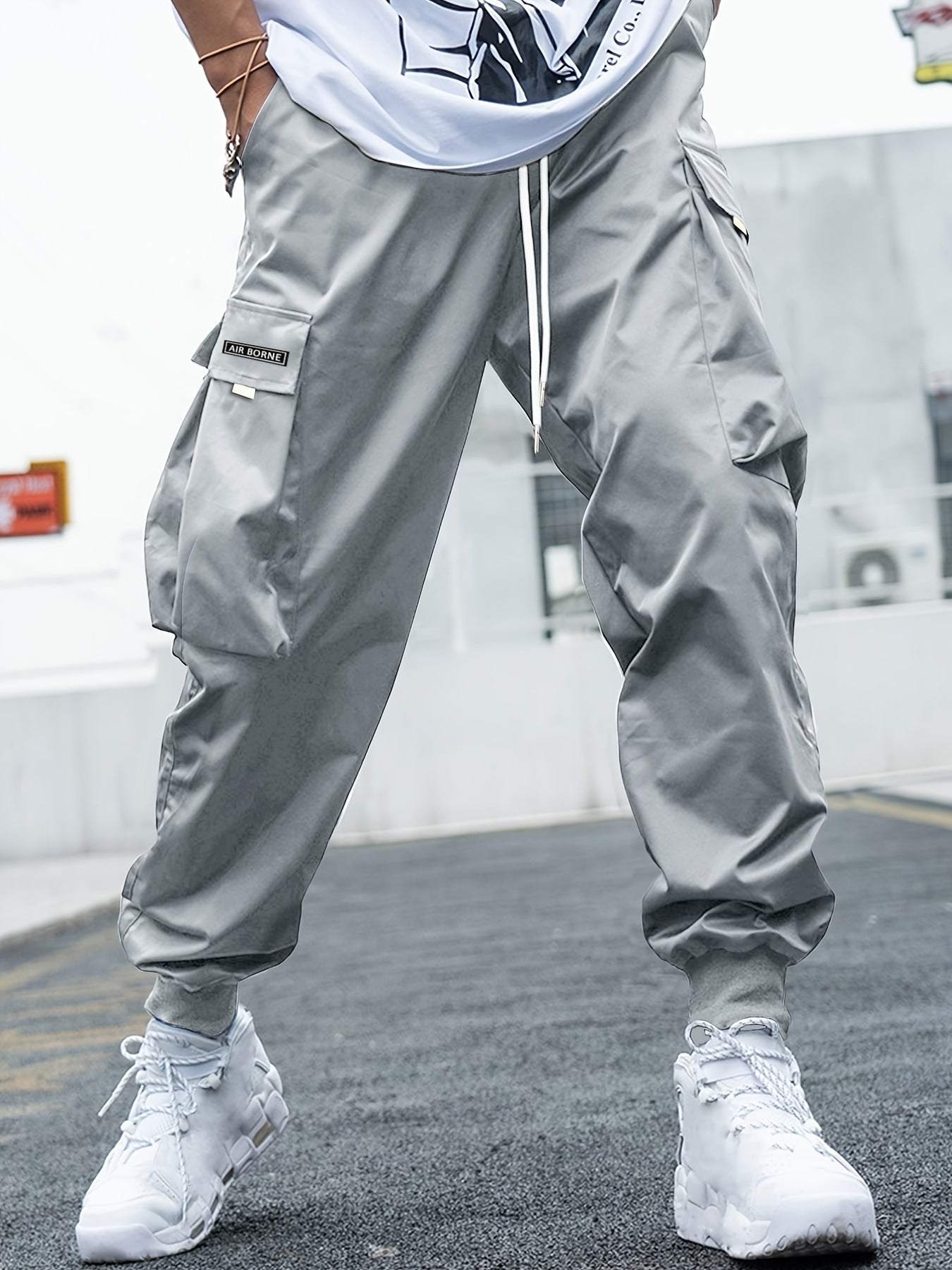 Men's grey multi-pocket cargo pants with drawstring waist, casual hip-hop style, outdoor streetwear design, polyester loose fit trousers