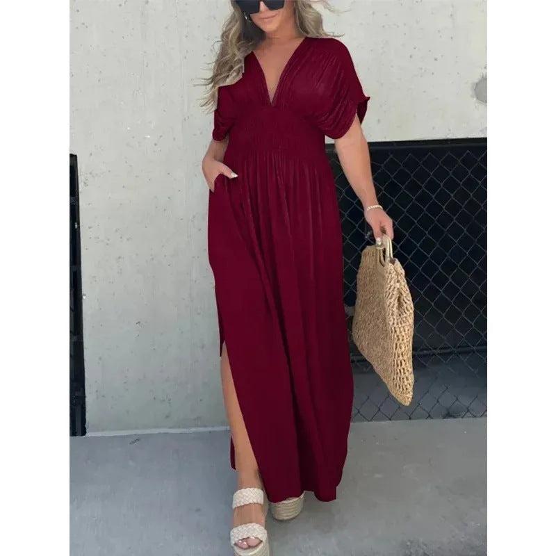 woman wearing red bat-sleeved V-neck slit dress with elastic waist holding woven bag
