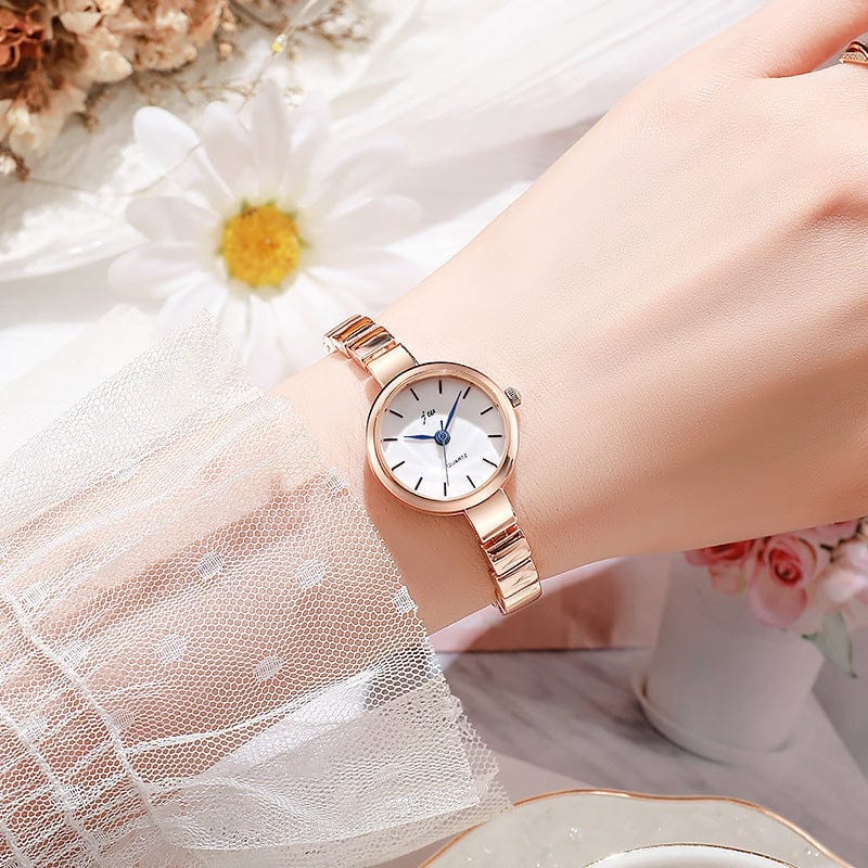 Niche steel women's watch with gold strap and white dial on wrist with floral background