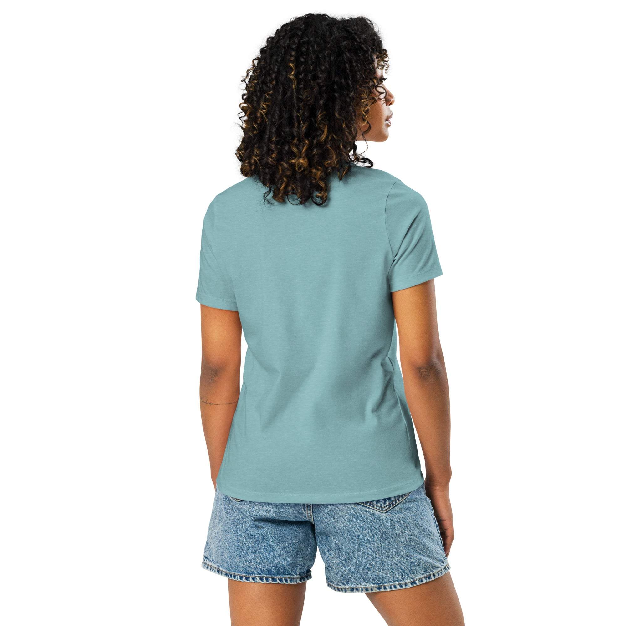 Back view of a woman wearing a light blue Break Boundaries Evolve T-Shirt with short sleeves and denim shorts.