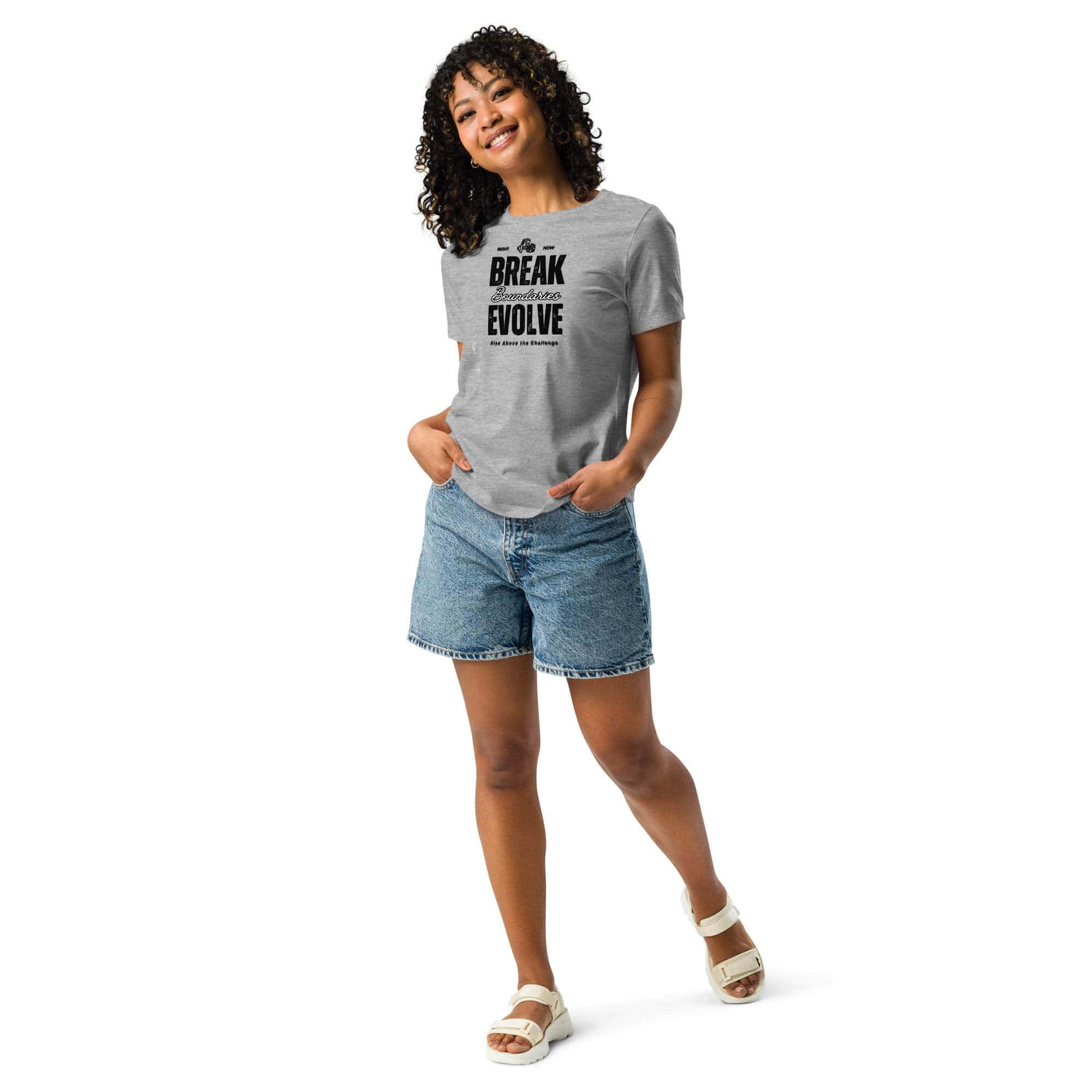 Woman wearing a gray Break Boundaries Evolve T-Shirt with black motivational text paired with denim shorts and white sandals