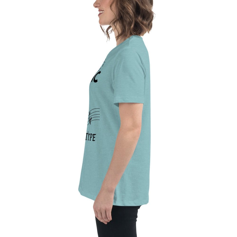 Side view of a woman wearing a light blue Music Girl T-Shirt with a musical notes graphic and text, styled with black pants