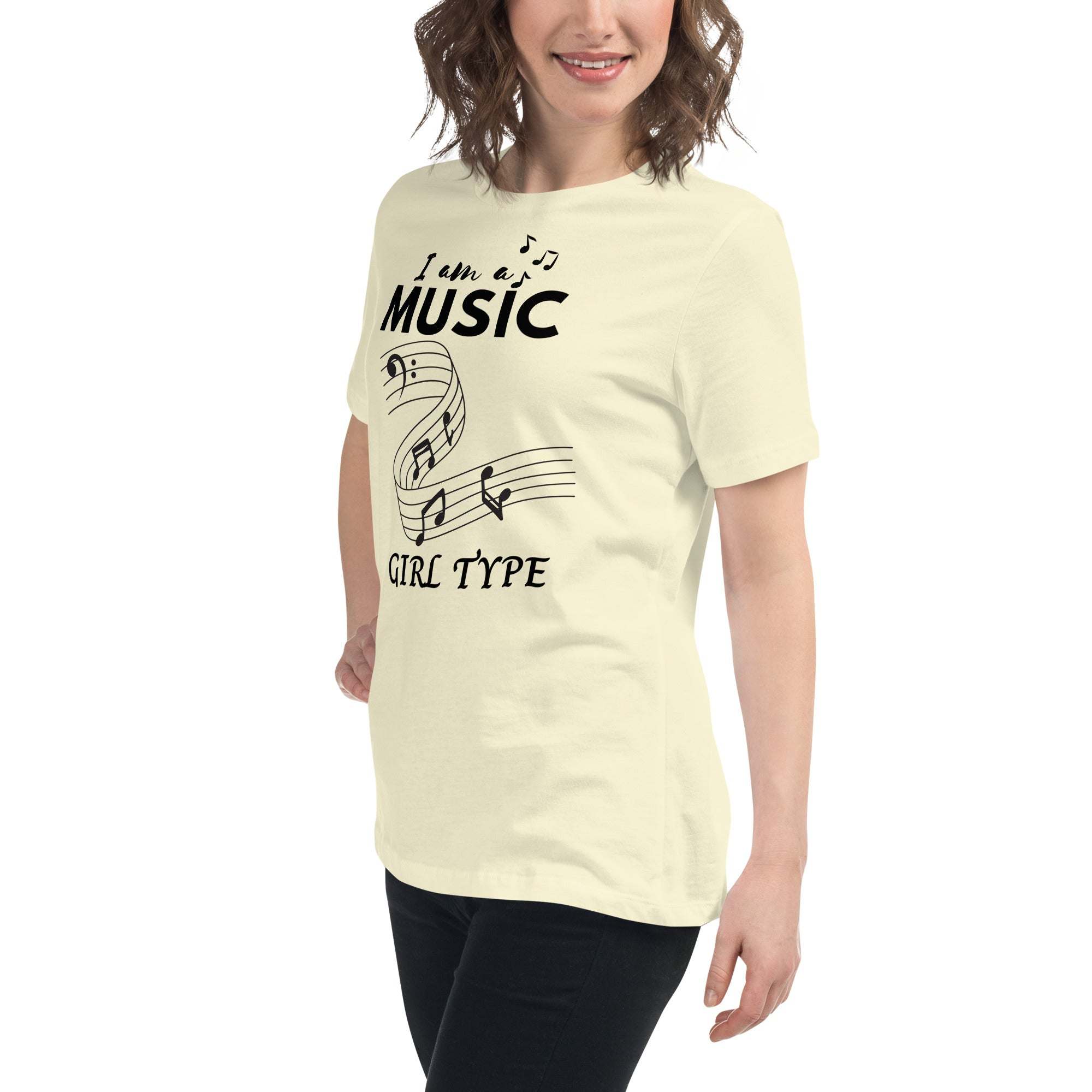 Woman wearing a soft cream Music Girl T-Shirt with black musical notes graphic and text, paired with black pants.