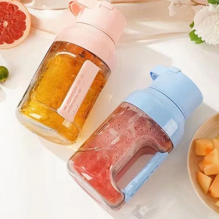 Portable summer electric juicer in pink and blue with double handles and 1500ml capacity blending fruit juices on a white surface