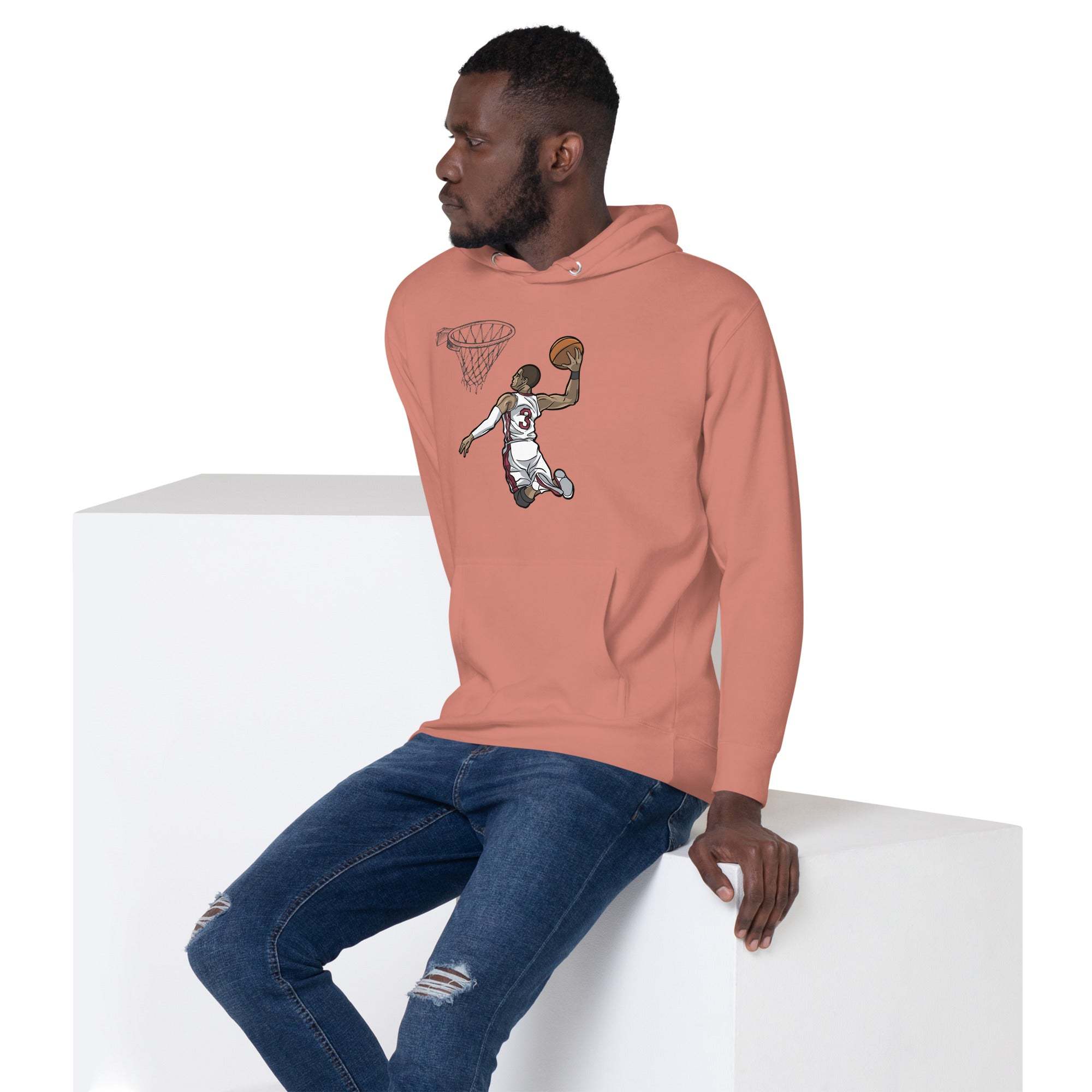 Man wearing a pink Basketball Dunk Hoodie with slam dunk graphic sitting on white blocks