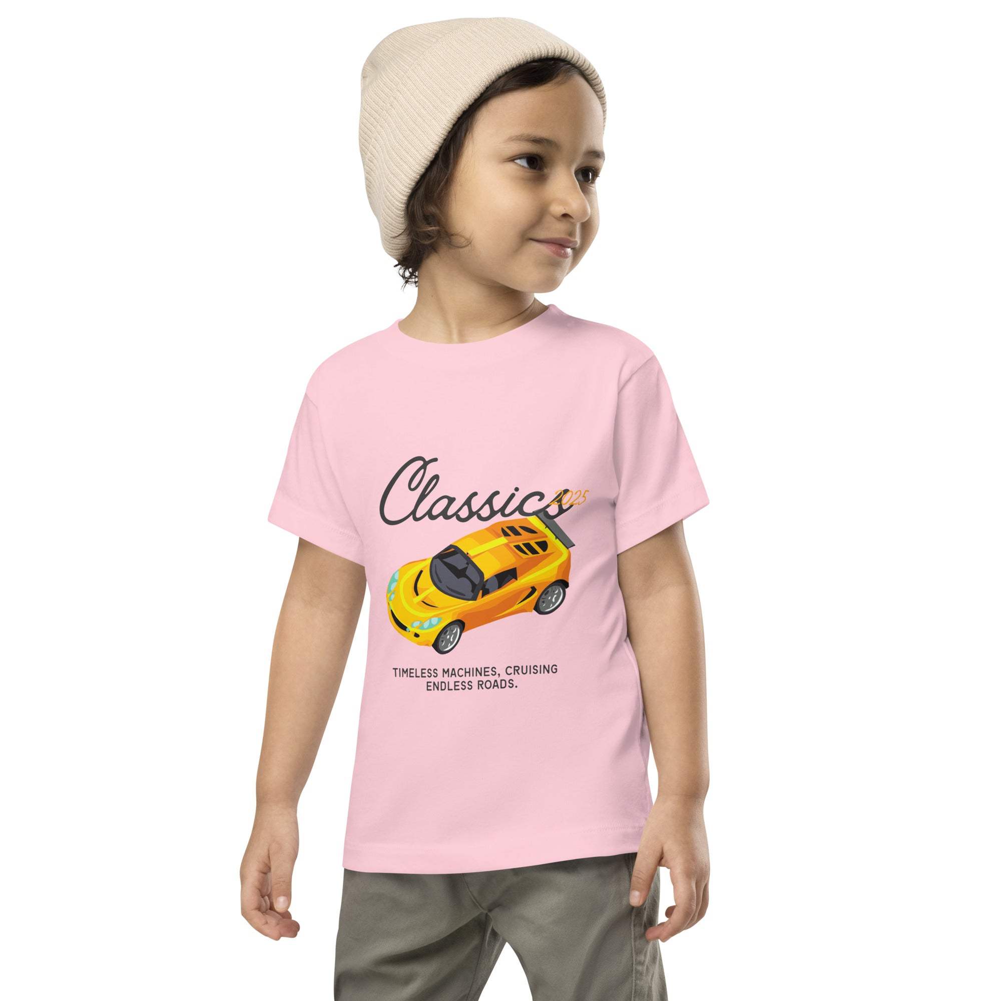 Toddler wearing pink Classic Car Kids T-Shirt with vintage yellow sports car design and beige beanie hat