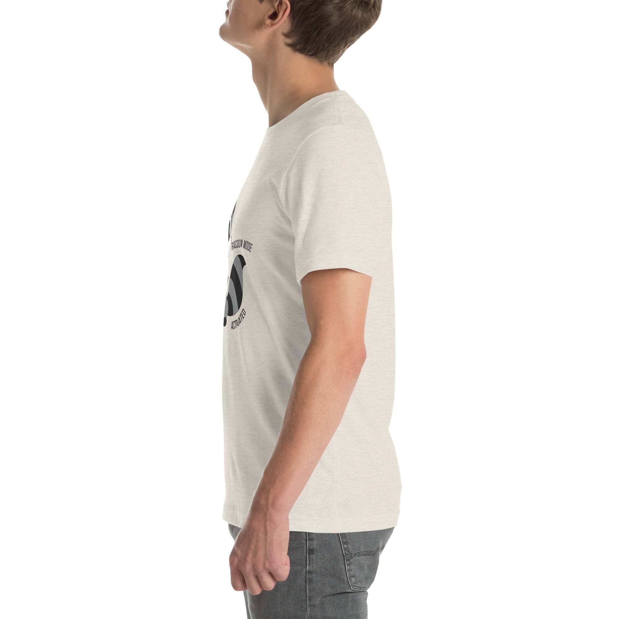 Side view of a man wearing a light-colored Raccoon Mode T-Shirt with cartoon raccoon and text design