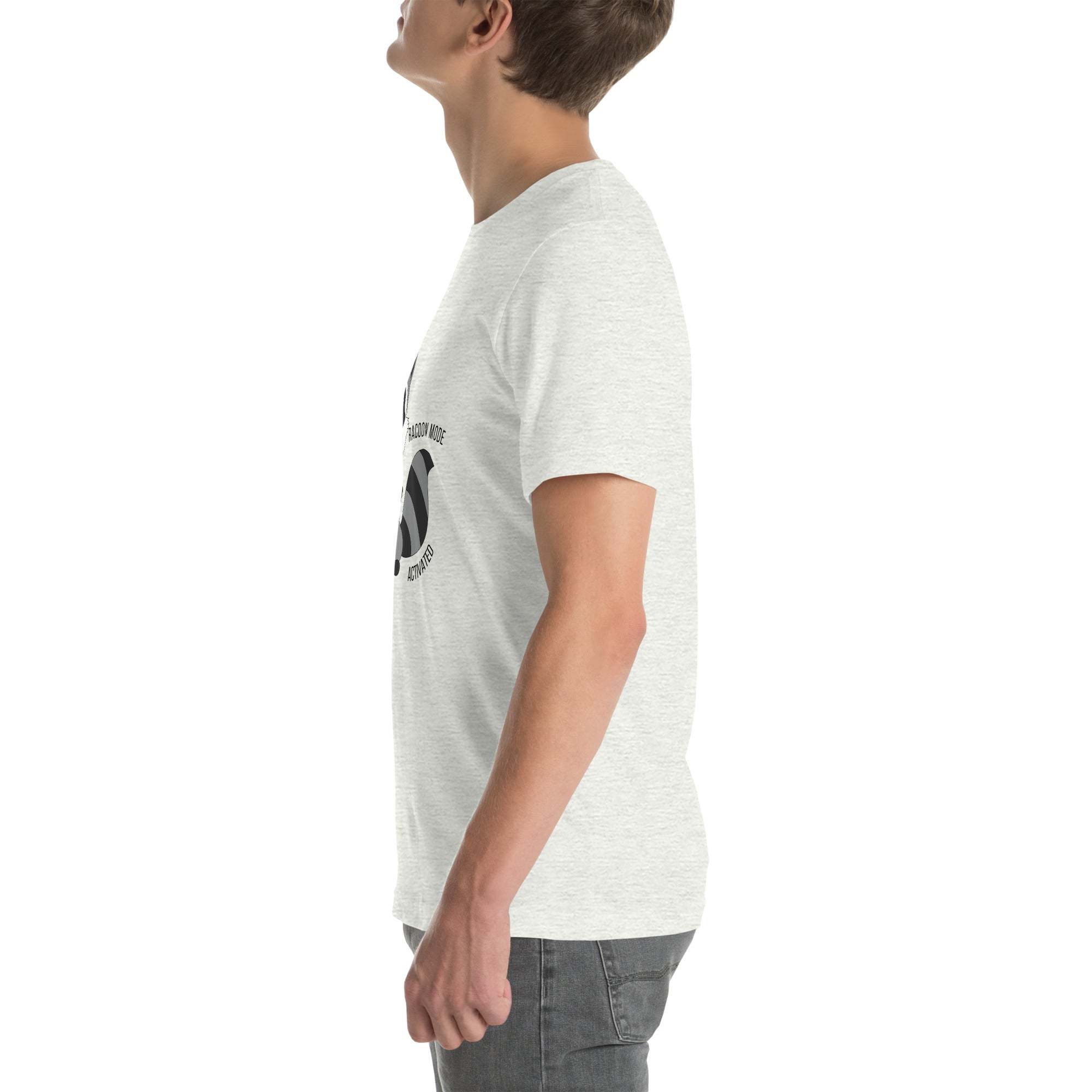 Side view of a man wearing a light gray Raccoon Mode T-Shirt with a cartoon raccoon and text design