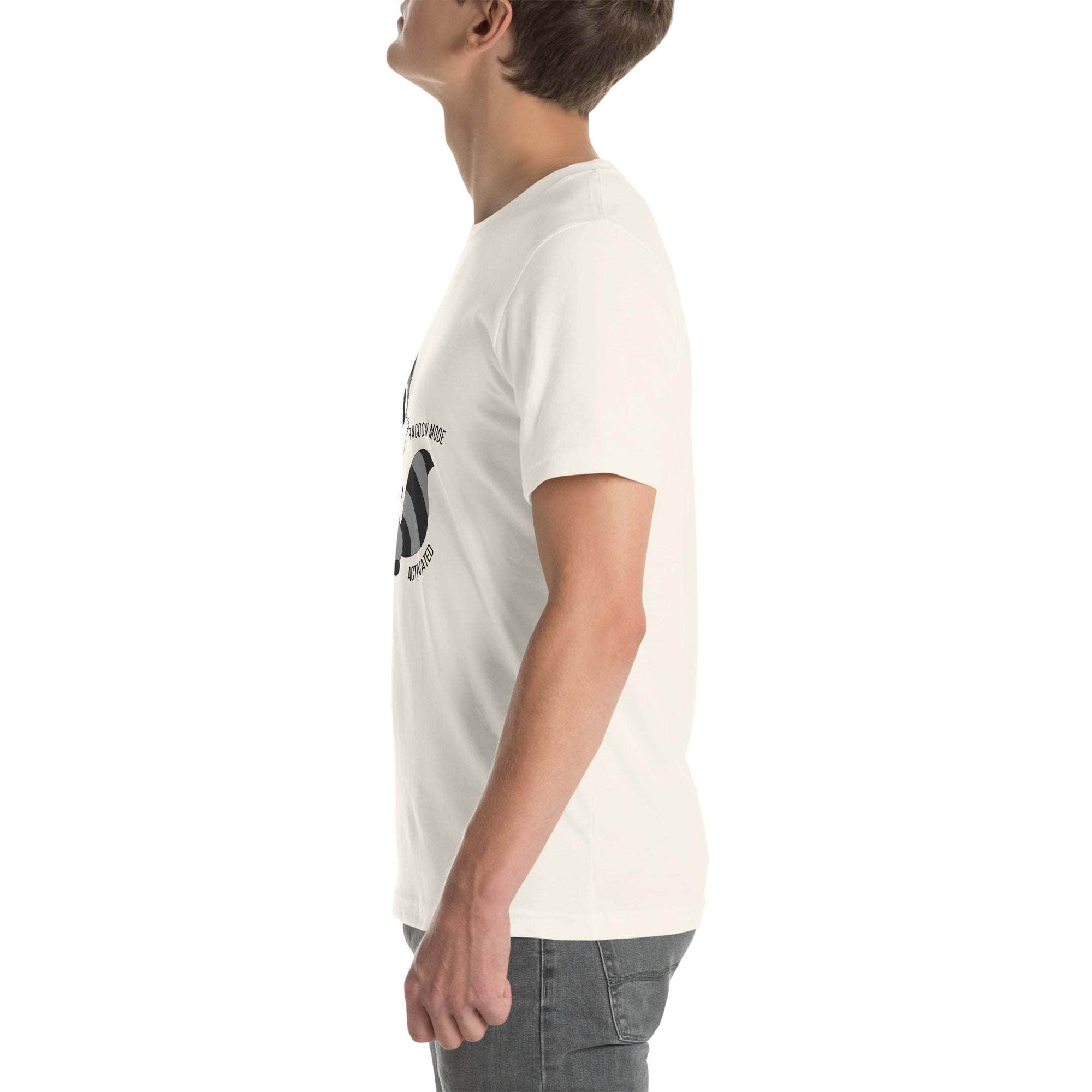 Side view of man wearing white soft cotton Raccoon Mode T-Shirt with cartoon raccoon and "Raccoon Mode Activated" text