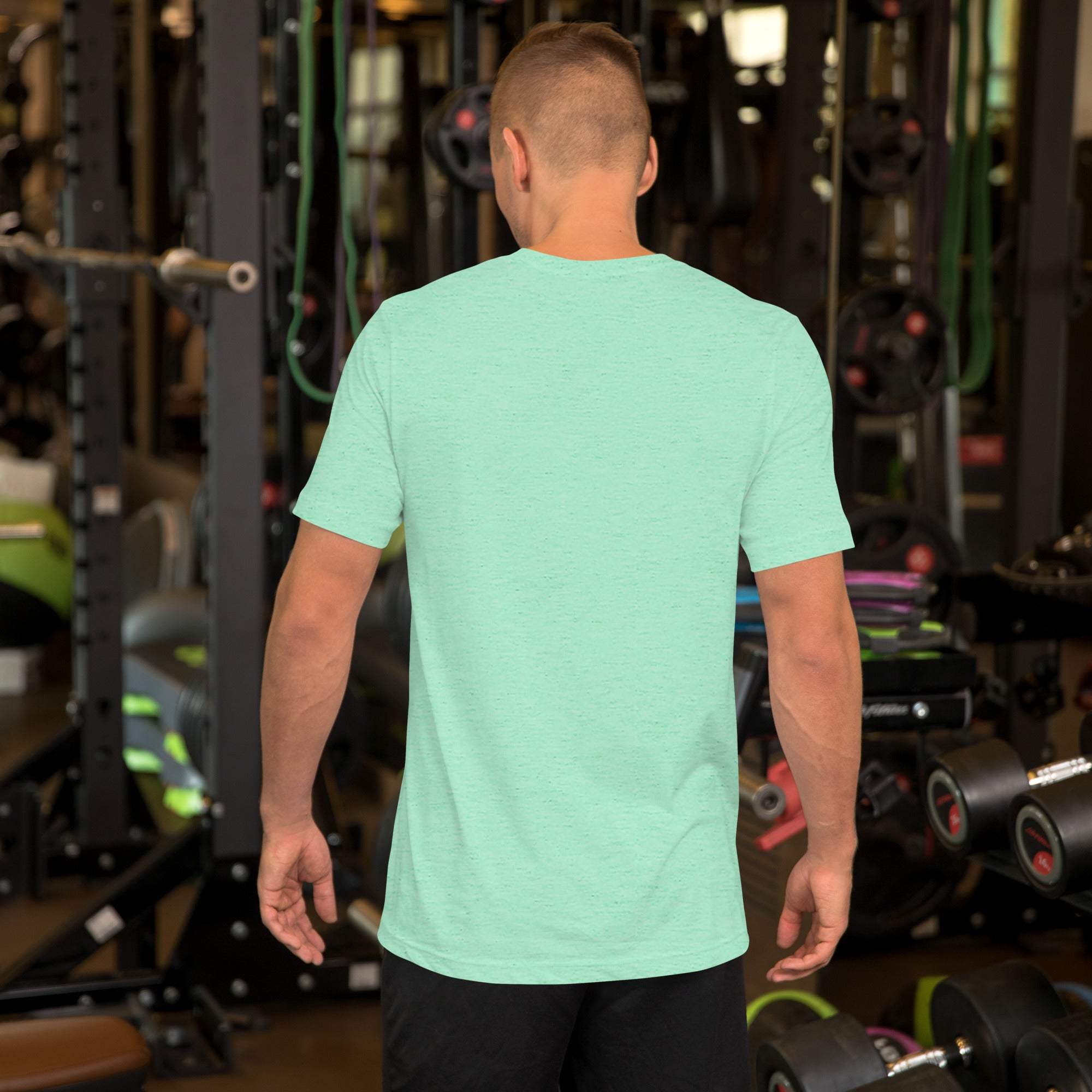 Man wearing mint green happy Father's Day T-shirt with heart and hand design in gym setting