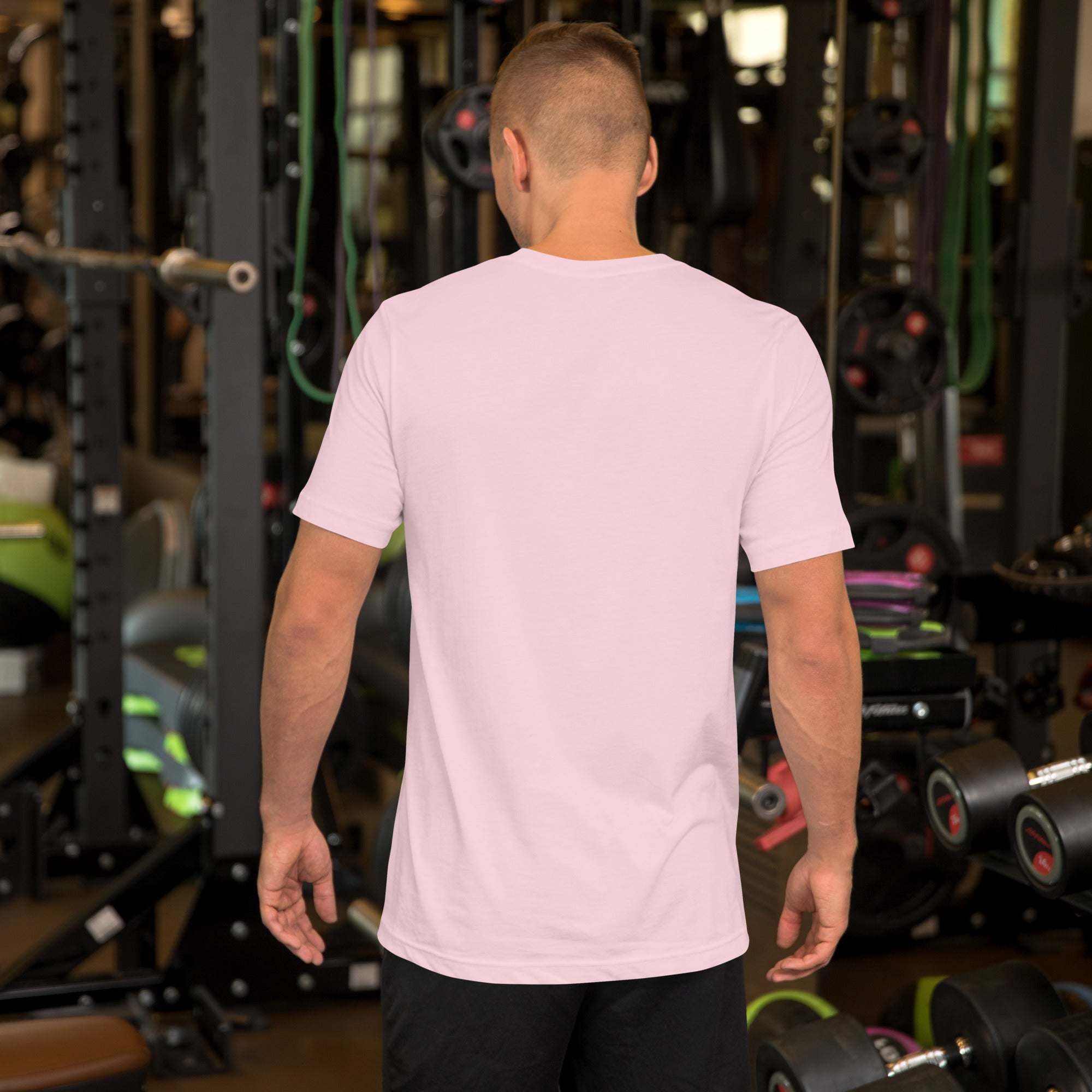Man wearing plain light pink Father's Day T-shirt with heart and hand design standing in gym back view