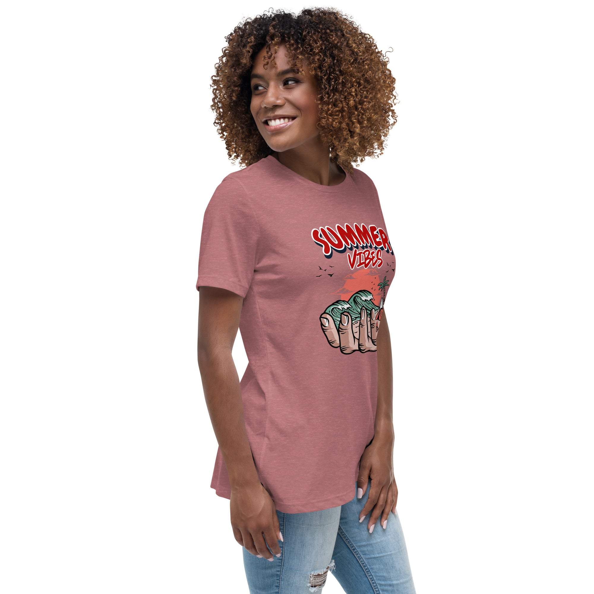 Woman wearing a pink Summer Vibes T-Shirt with a retro beach graphic held in a hand, paired with ripped jeans