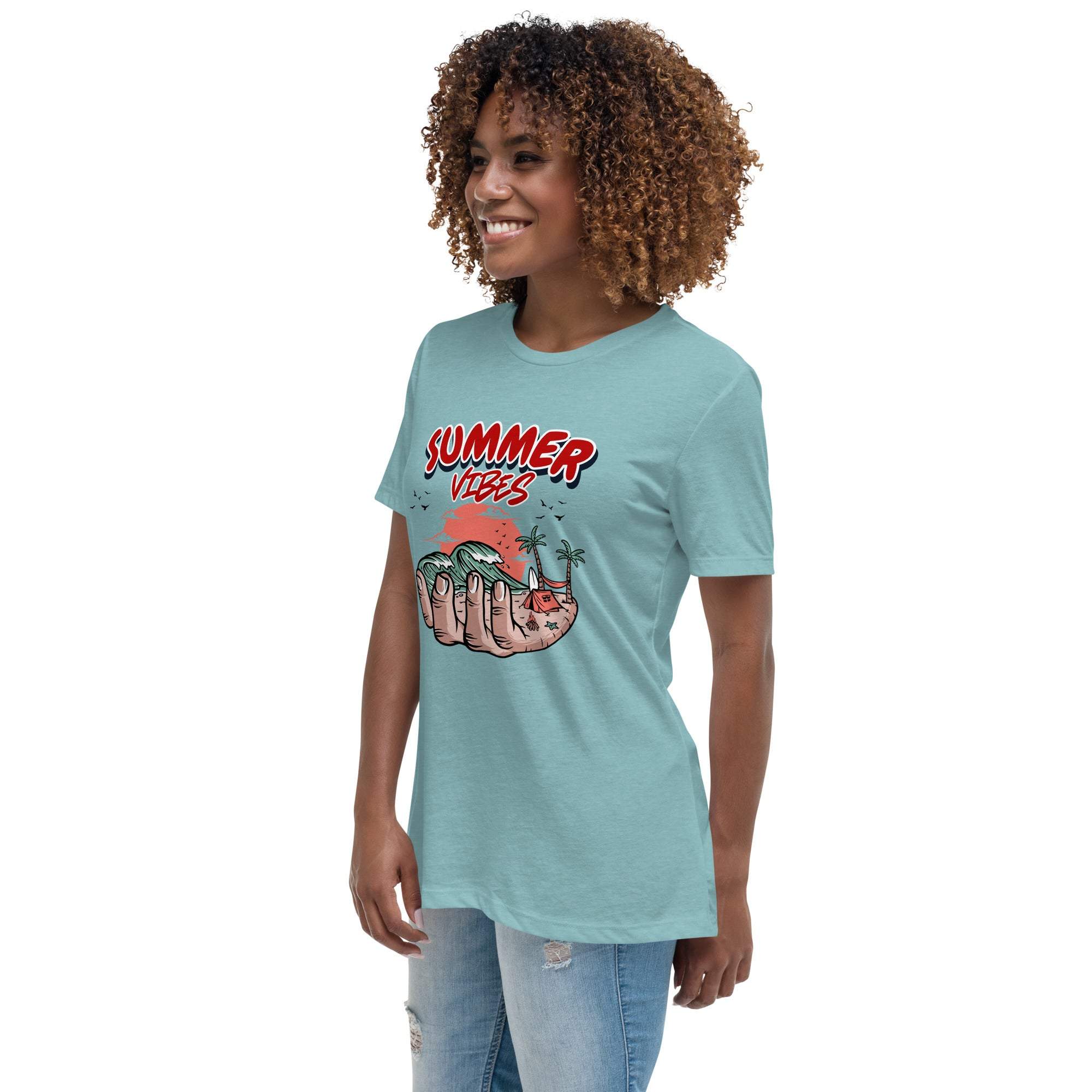 Woman wearing light blue Summer Vibes T-Shirt with retro beach graphic held in a hand and red text on front