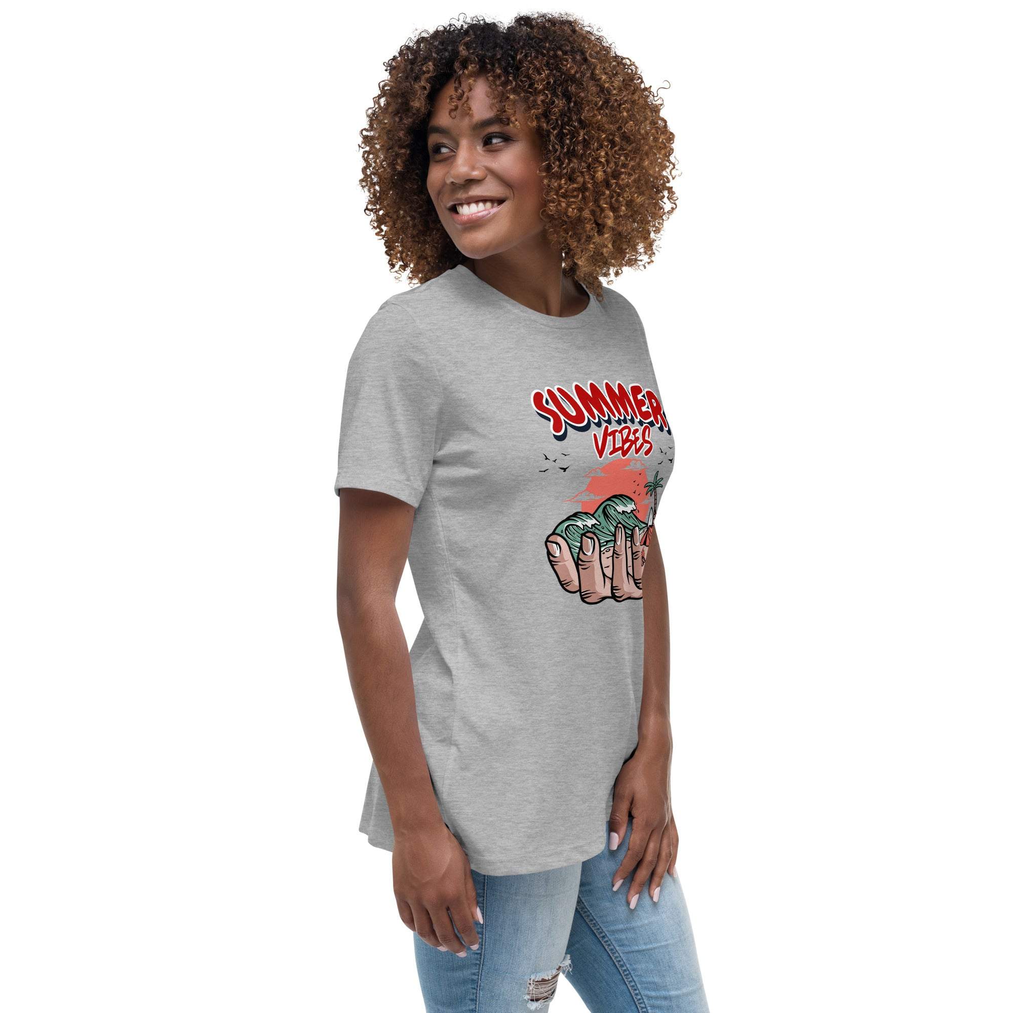 Gray Summer Vibes T-shirt with retro beach graphic held in hand, worn by smiling woman in casual jeans.