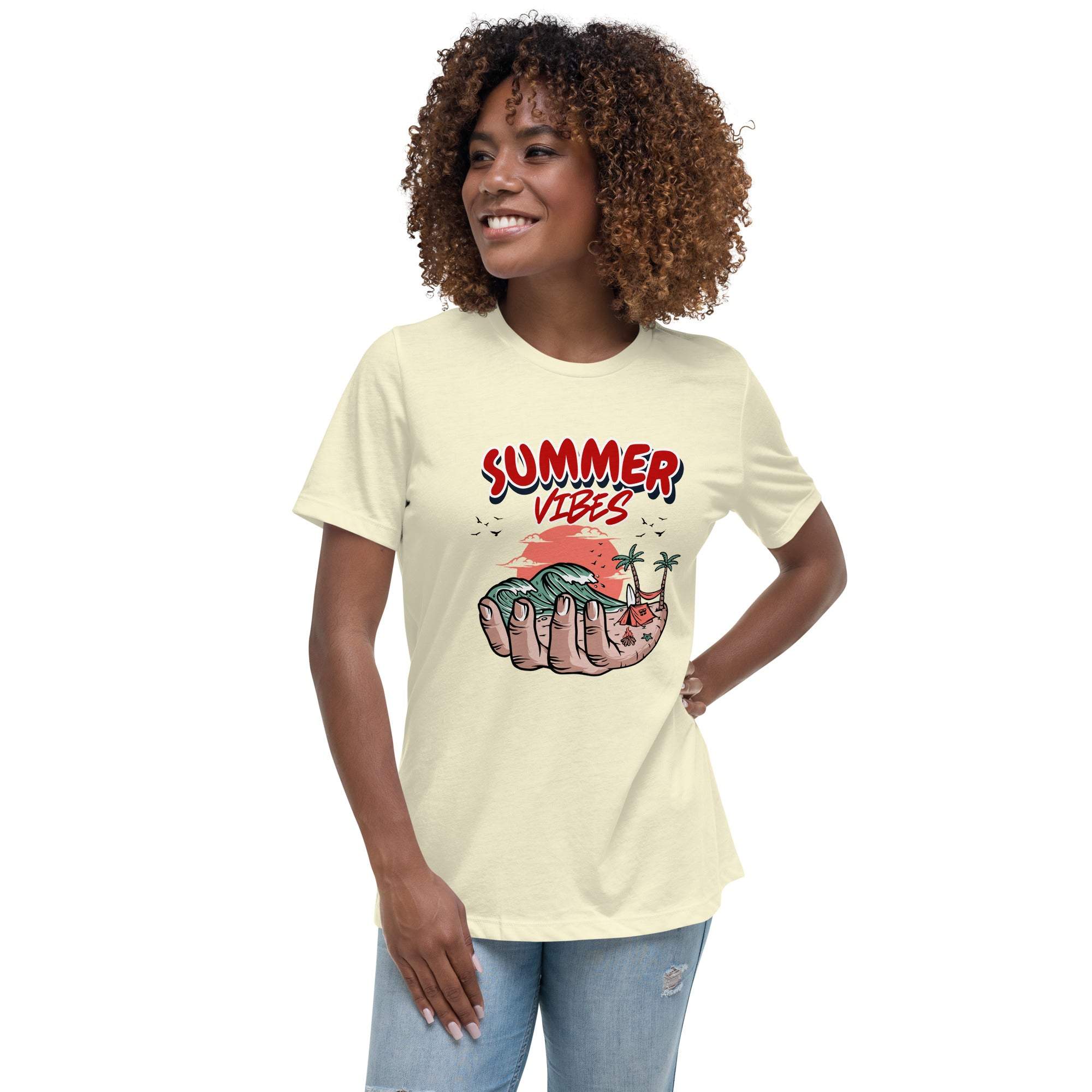 Woman wearing a cream Summer Vibes T-Shirt with a retro beach graphic of a hand holding a tropical scene with palm trees and waves.