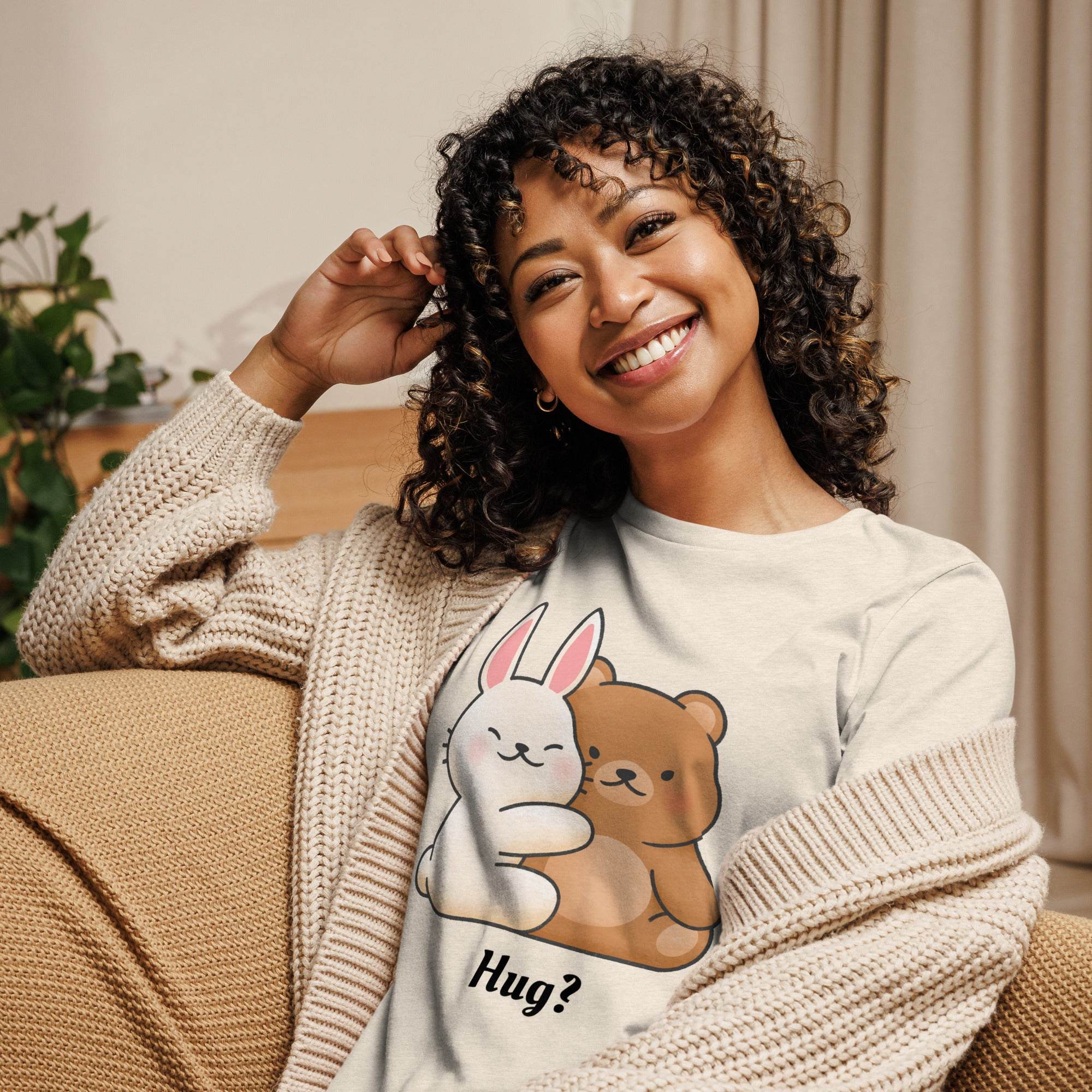 Woman wearing a Cute Bunny and Bear Hug T-Shirt with a cozy knit cardigan sitting on a couch smiling