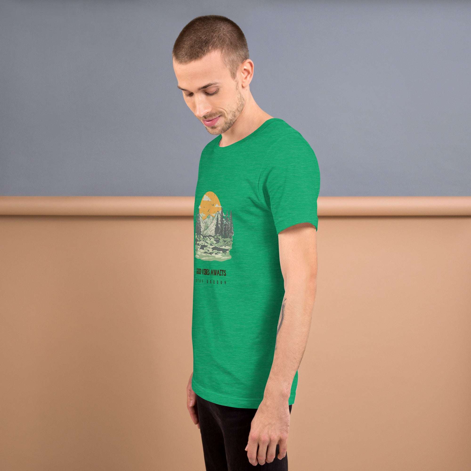 Man wearing green Good Vibes T-Shirt with mountain and sunset graphic, soft lightweight cotton tee