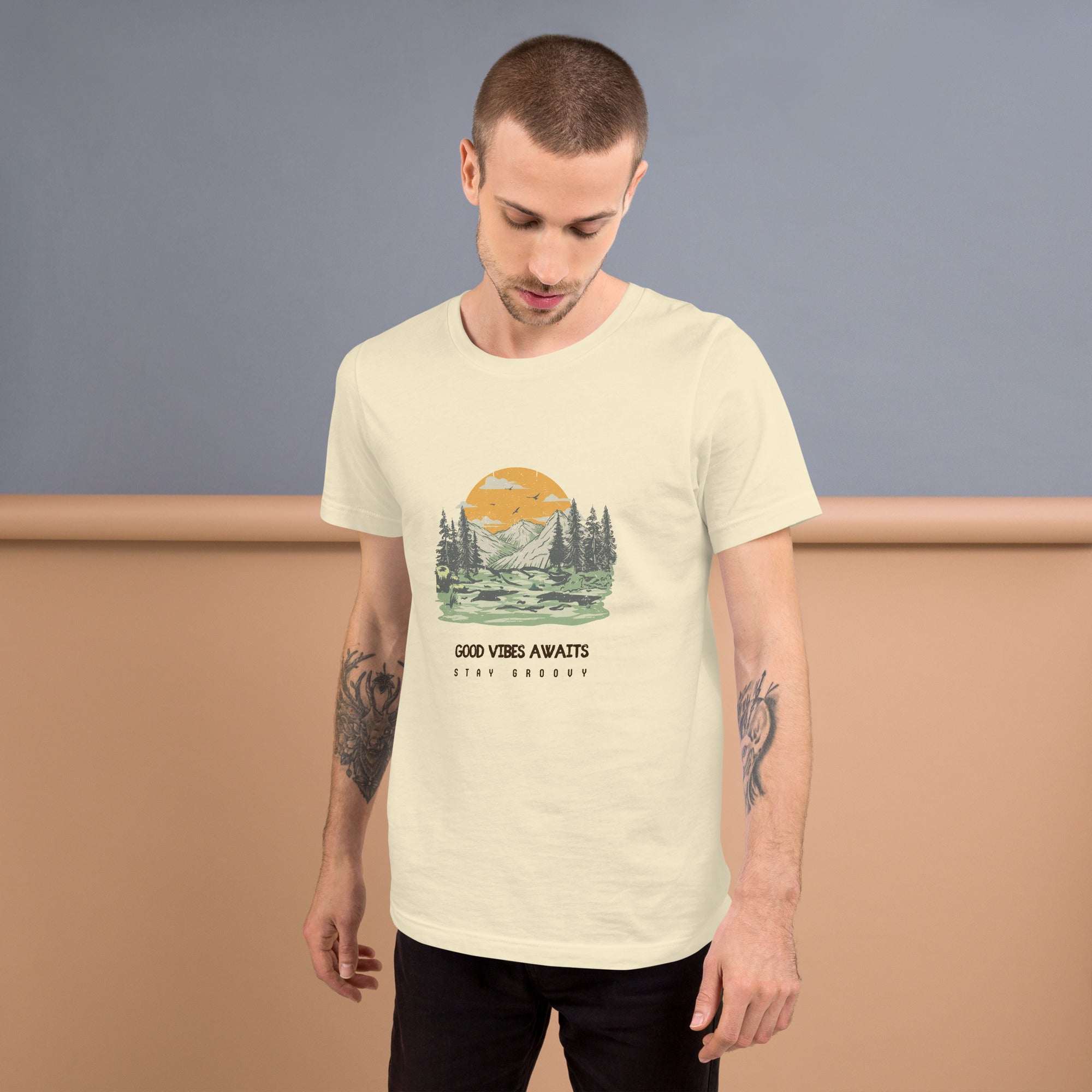 Man wearing off-white Good Vibes Awaits T-Shirt with nature graphic and text, soft and lightweight cotton tee