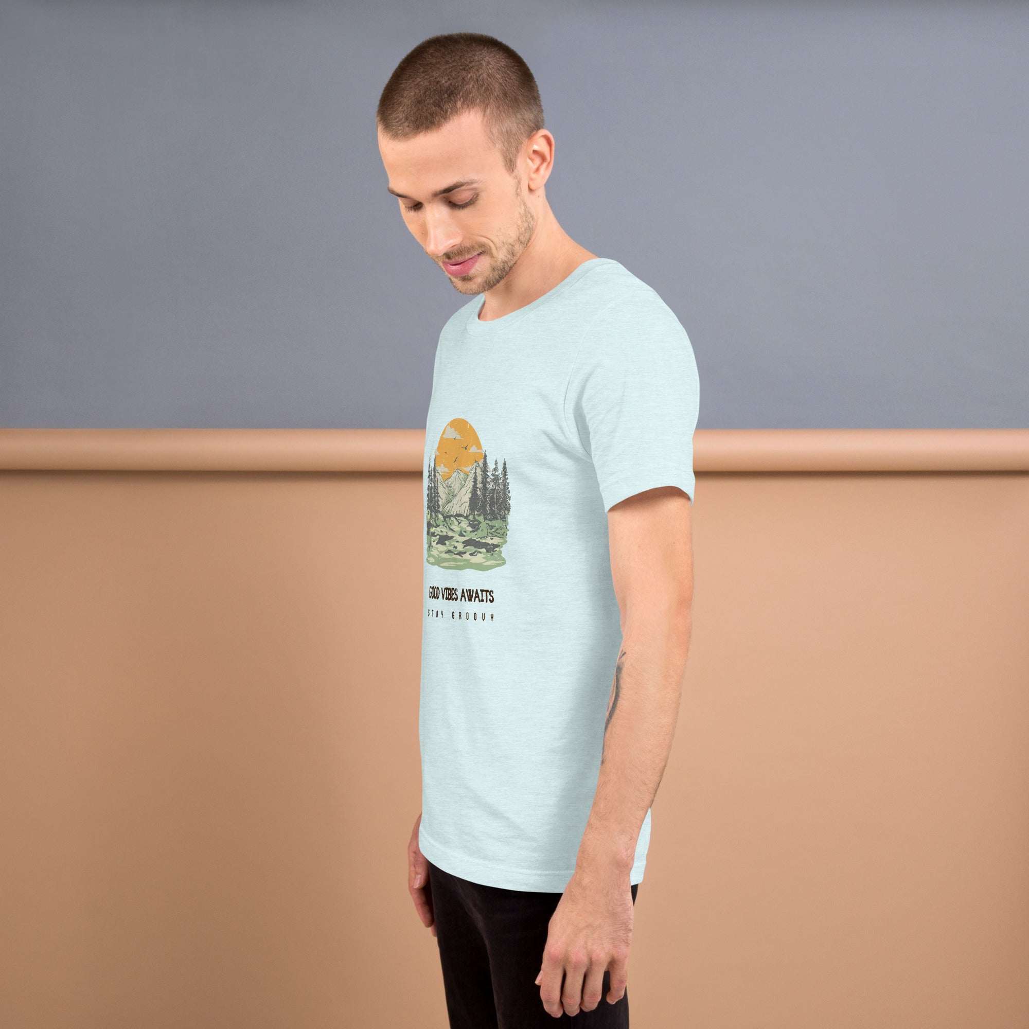 Man wearing light blue Good Vibes Awaits T-Shirt with nature graphic, side view, soft lightweight cotton