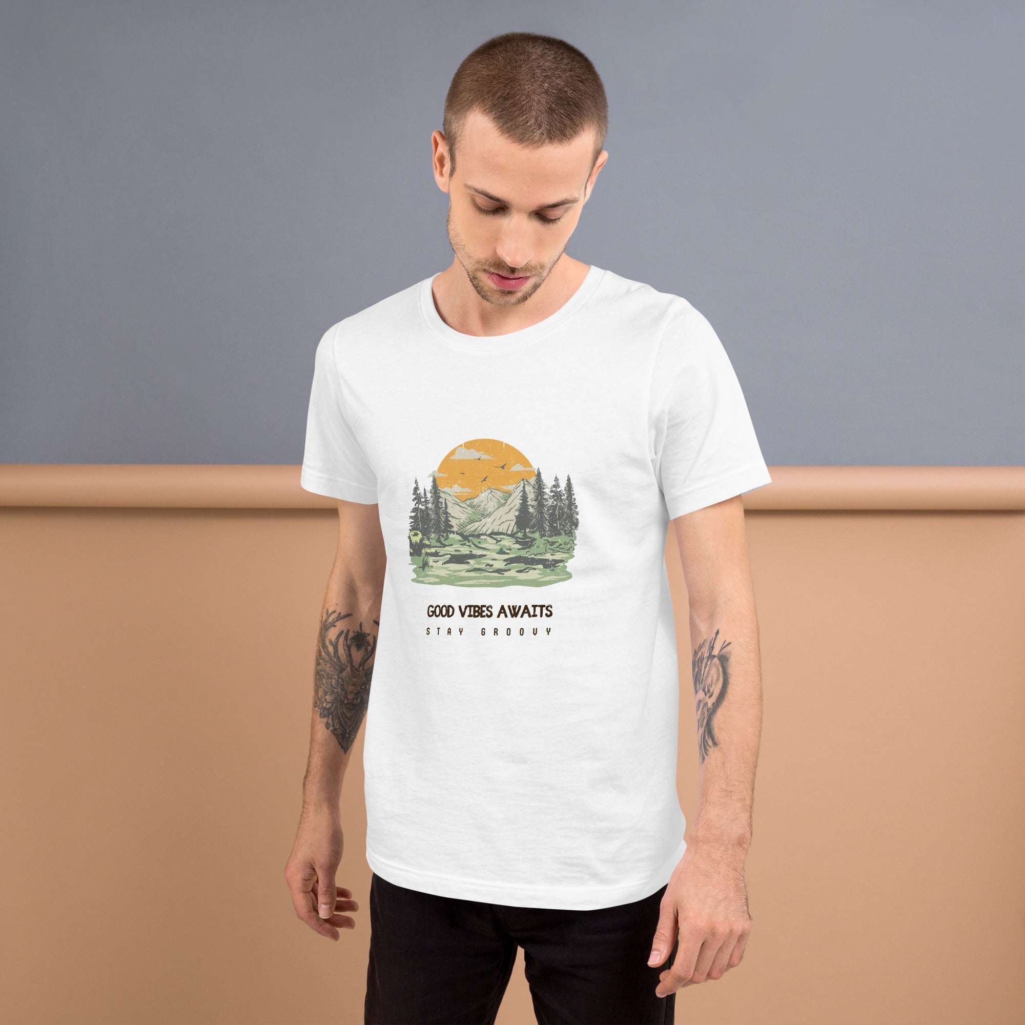 Man wearing white Good Vibes Awaits T-Shirt with mountain and forest graphic design