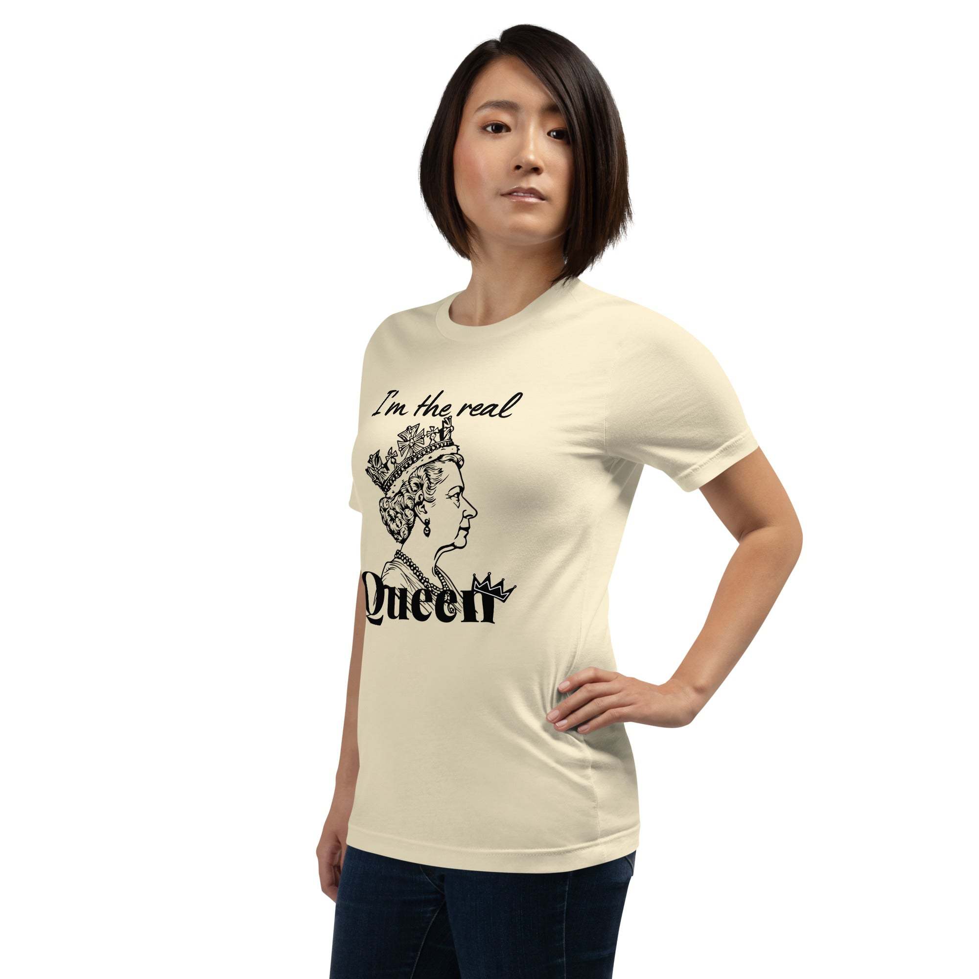 Woman wearing beige "I'm the Real Queen" T-shirt with queen crown graphic and bold text, styled casually