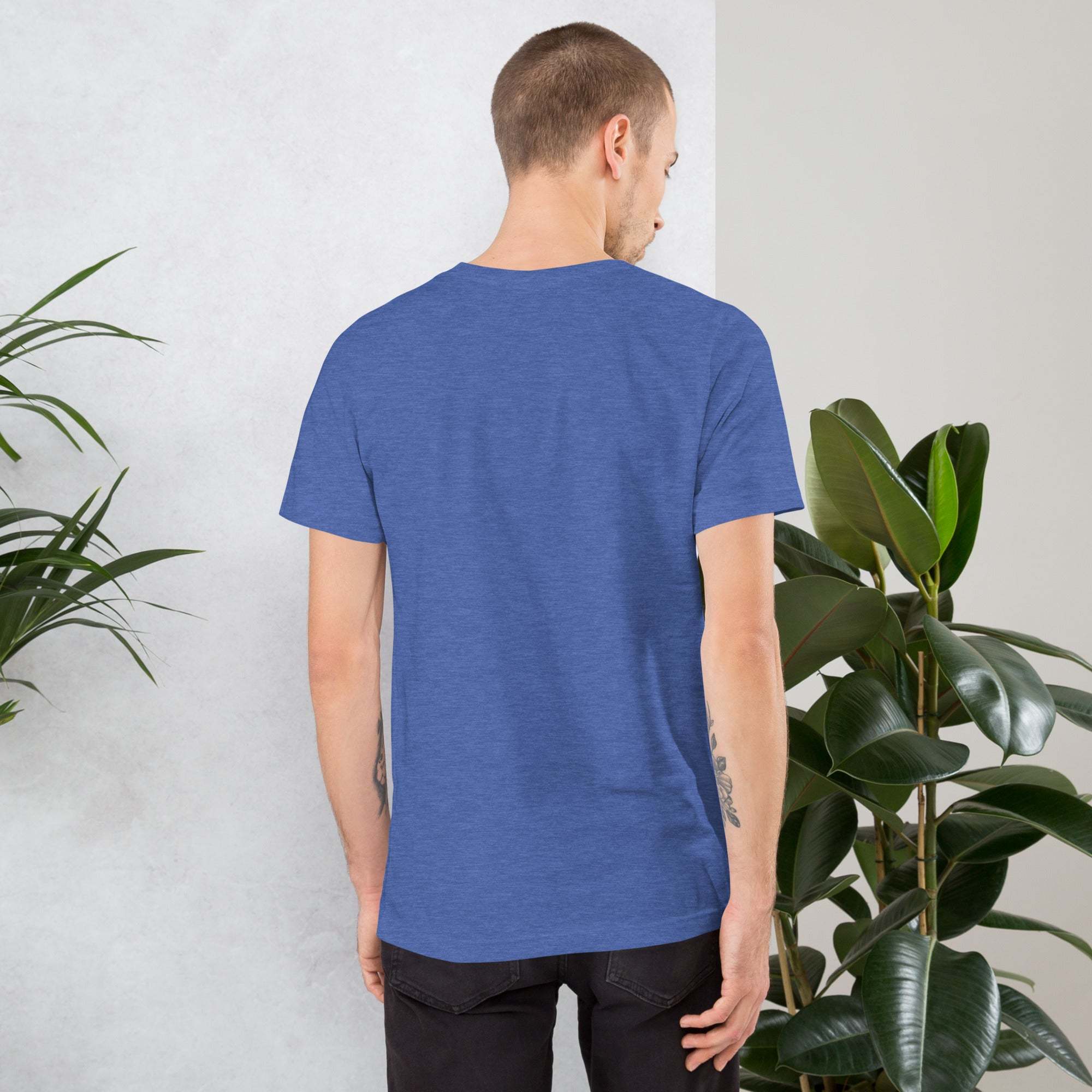 Man wearing blue Midwest T-Shirt standing near plants with back facing camera