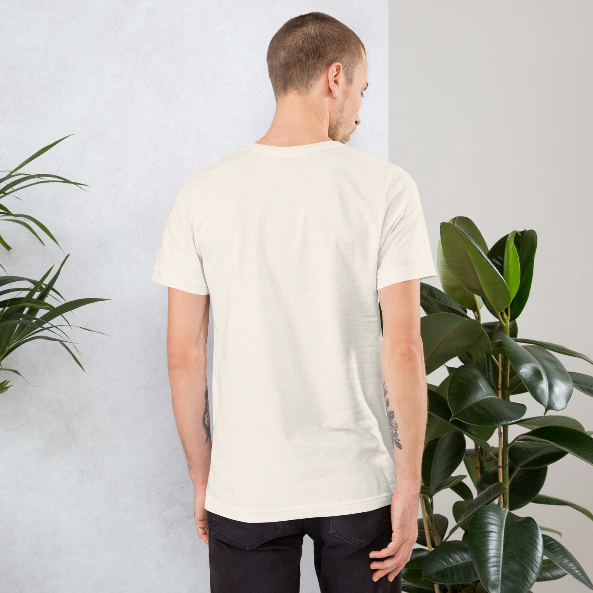 Back view of man wearing plain white Midwest T-Shirt standing near green plants indoors