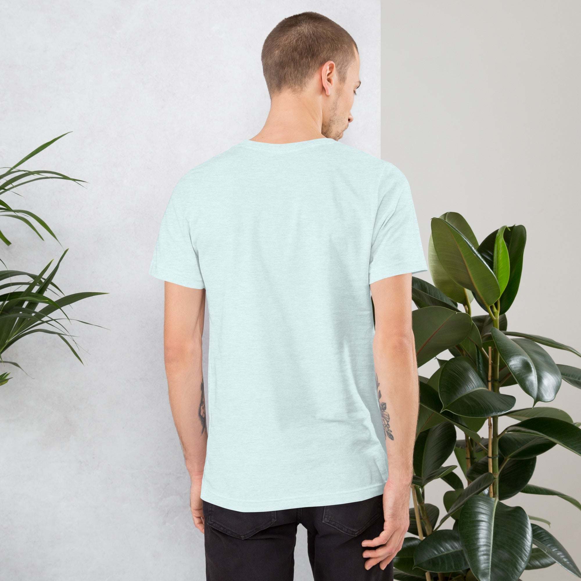 Man wearing light blue Midwest T-Shirt standing near green plants showing back view