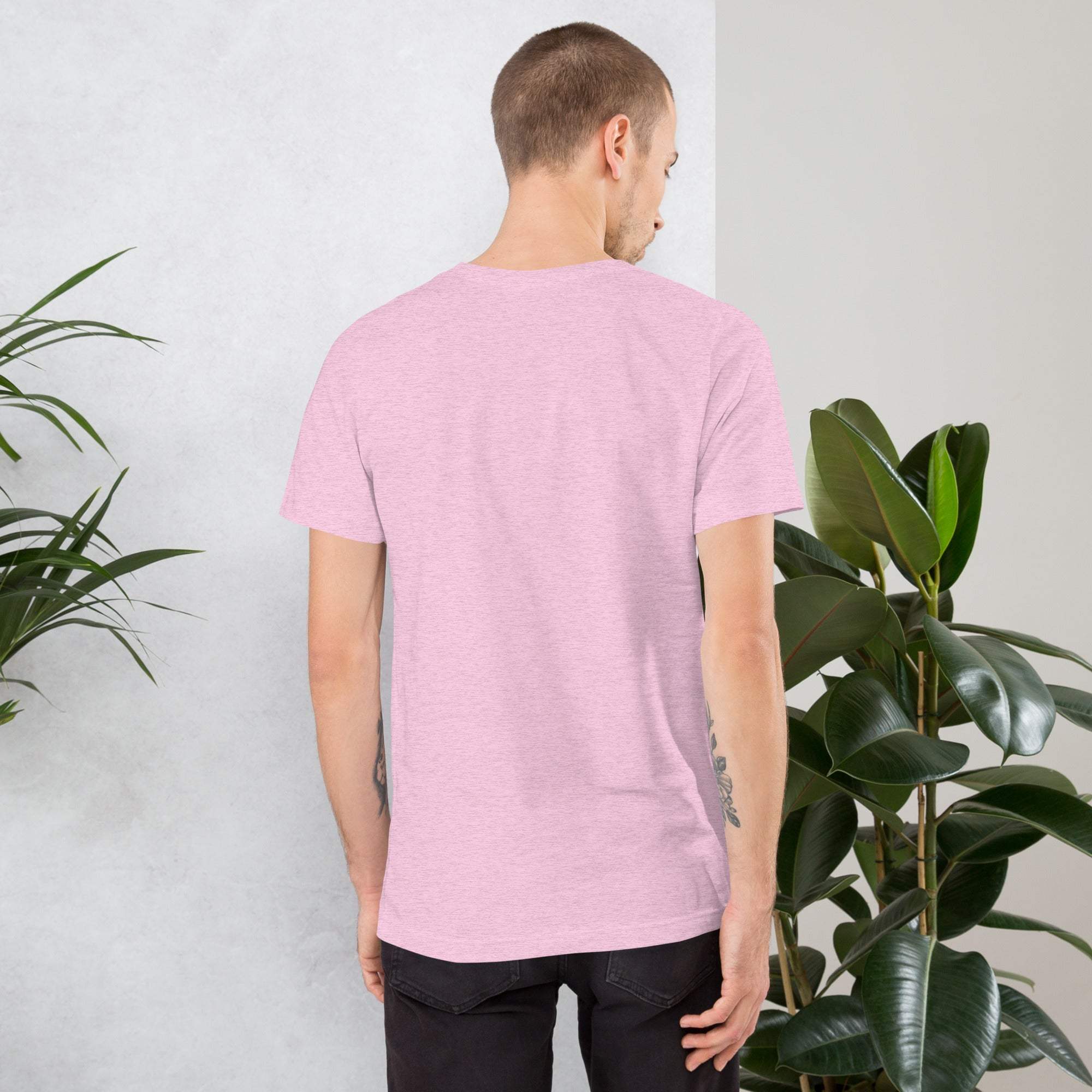 Back view of man wearing soft pink vintage aesthetic Frog and Mushroom T-Shirt standing near green plants