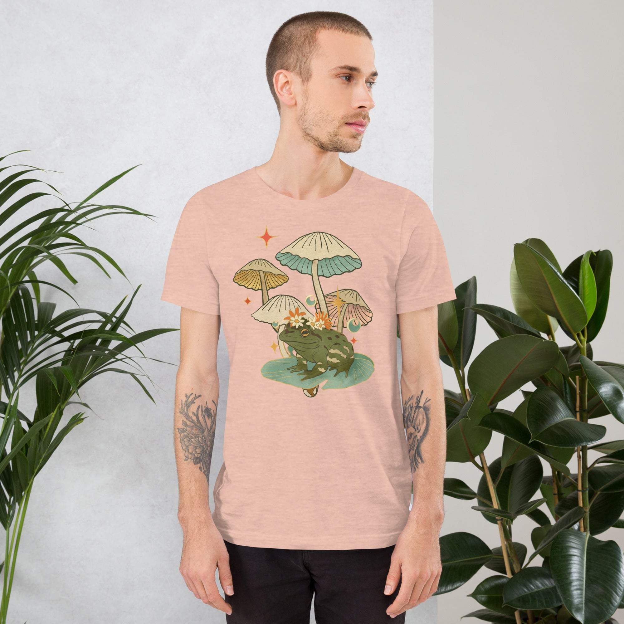 man wearing vintage aesthetic frog and mushroom t-shirt with nature-inspired graphic design