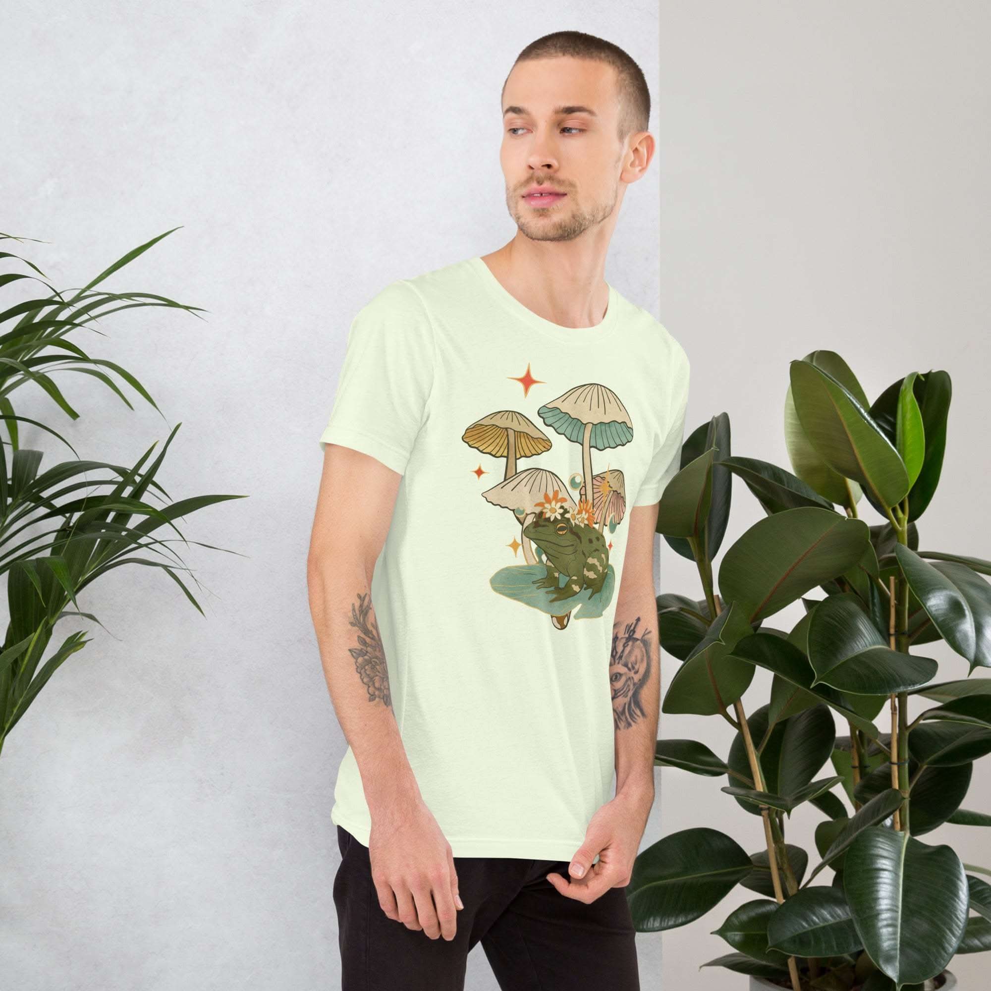 Man wearing vintage aesthetic frog and mushroom t-shirt with nature-inspired design
