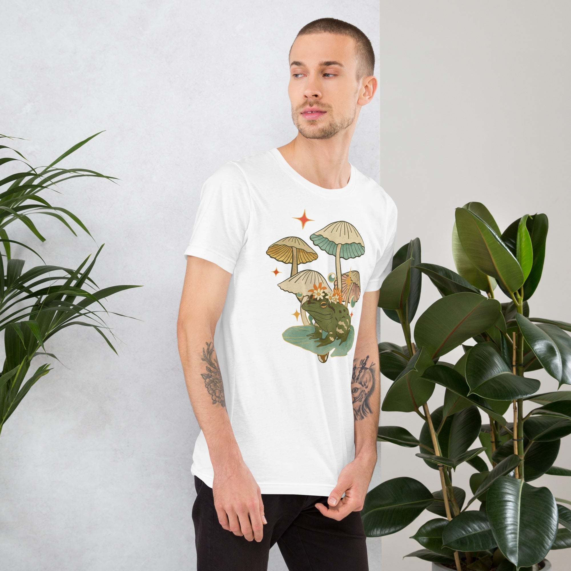 Man wearing white vintage aesthetic frog and mushroom t-shirt with nature-inspired graphic design
