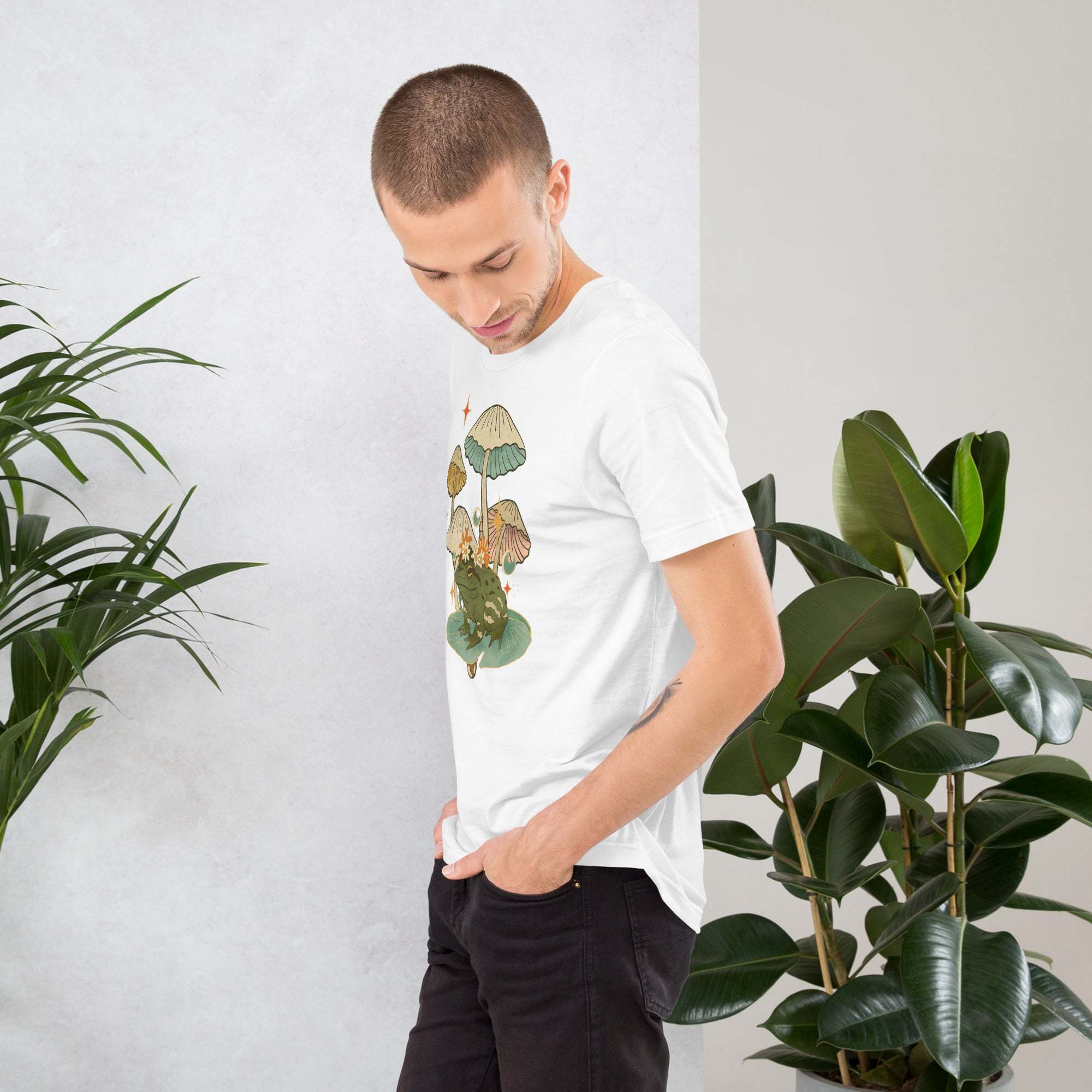 Man wearing white vintage aesthetic frog and mushroom T-shirt with nature-inspired graphic design